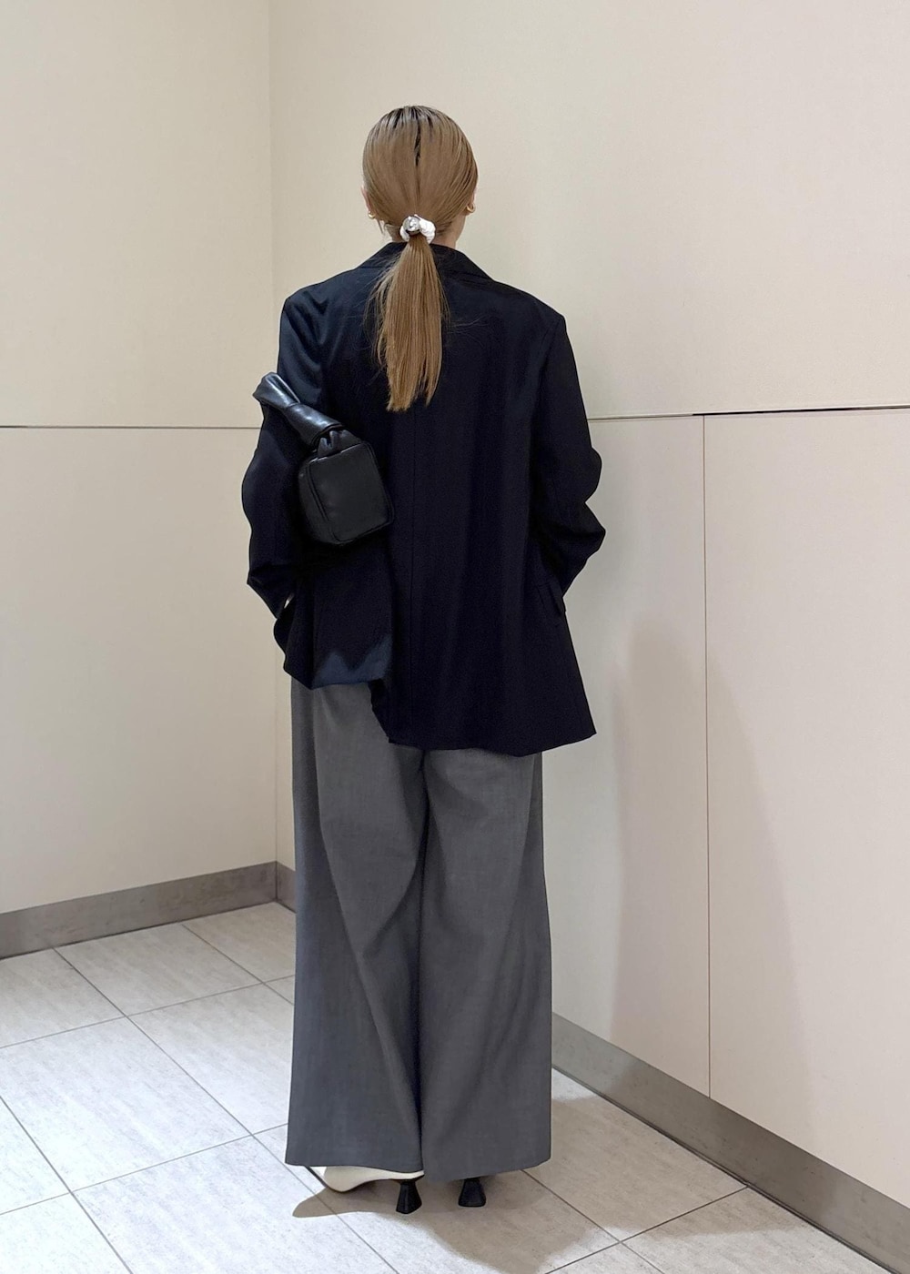 ホワイト系のパンプス、ブラック系のテーラードジャケット、ブルー系のつなぎ/オールインワンを着用したレディースの冬コーディネートの4枚目の写真