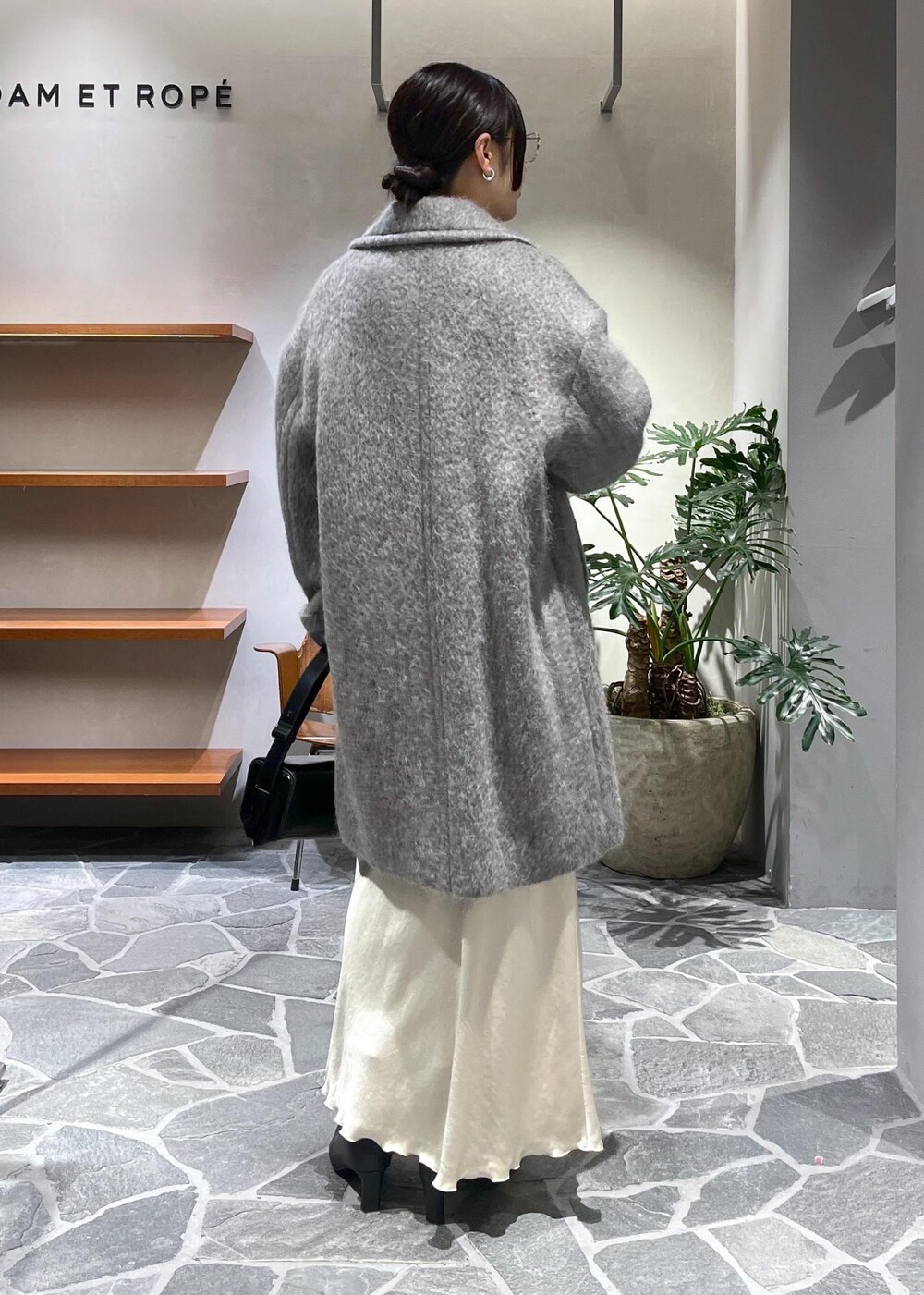 ブラック系のブーツ、ベージュ系のスカート、ブラック系のカーディガン/ボレロを着用したレディースの冬コーディネートの3枚目の写真