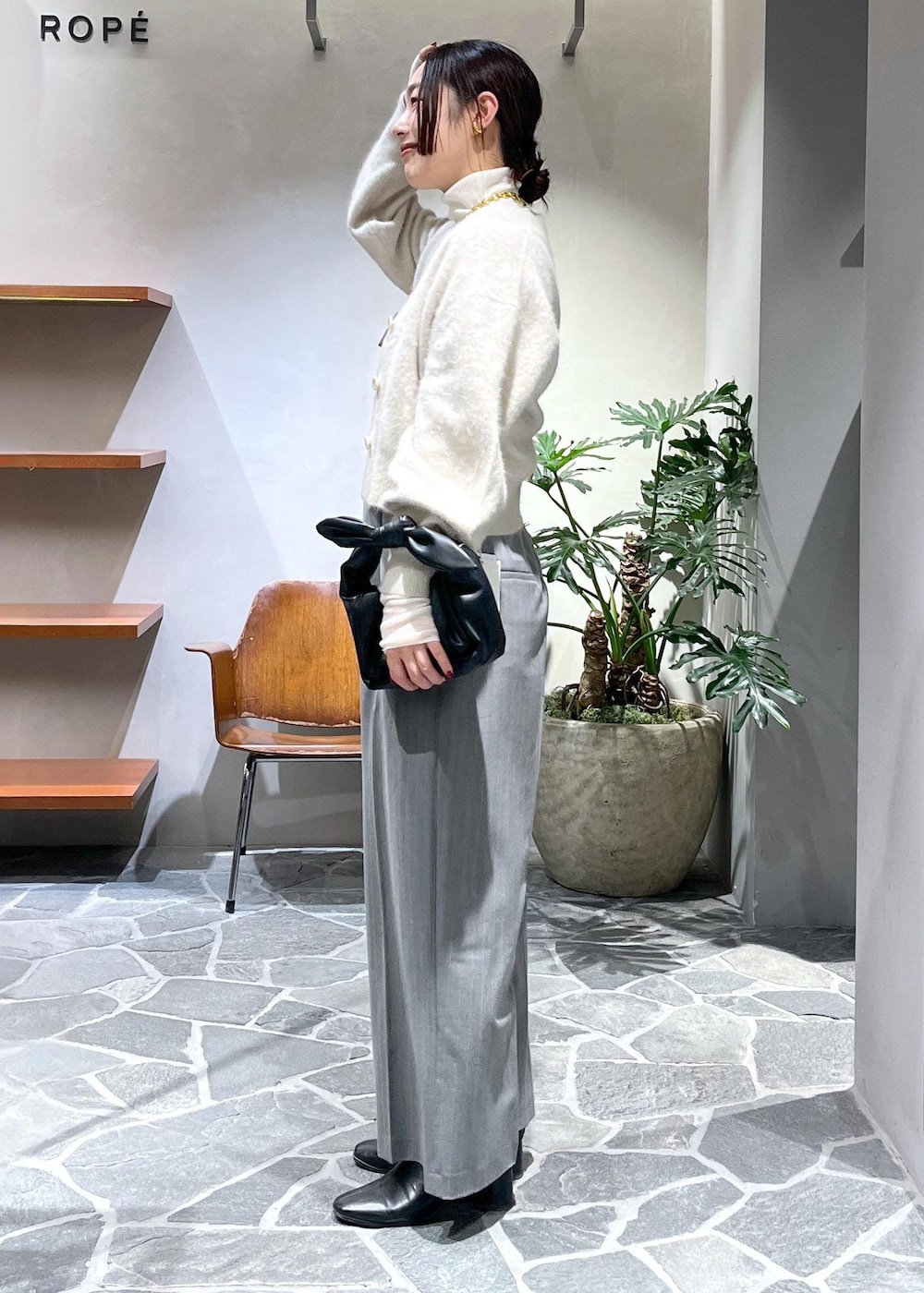 ホワイト系のカーディガン/ボレロ、ホワイト系のニット/セーター、ブラック系のショルダーバッグを着用したレディースの冬コーディネートの2枚目の写真