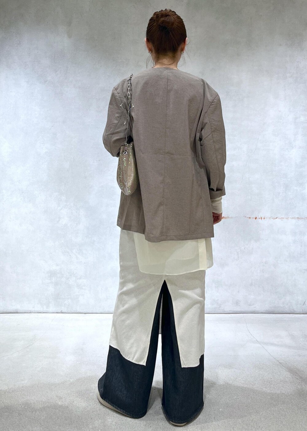 ベージュ系のセットアップ、ブラック系のデニムパンツ、その他のハンドバッグを着用したレディースの春コーディネートの3枚目の写真