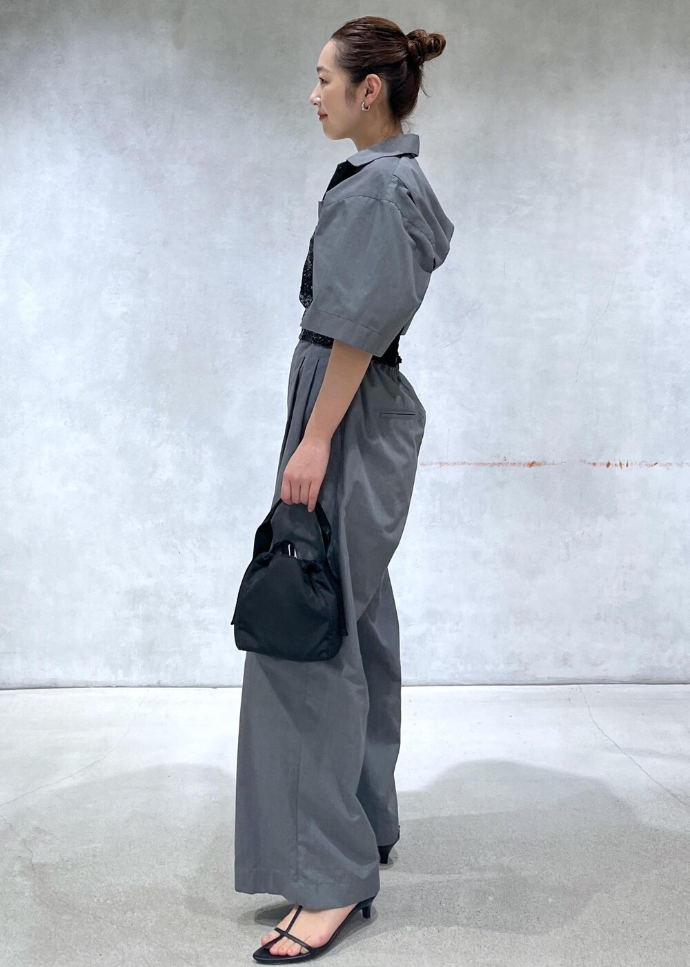 ブラック系のサンダル、ブラック系のハンドバッグ、グレー系のつなぎ/オールインワンを着用したレディースの春コーディネートの2枚目の写真
