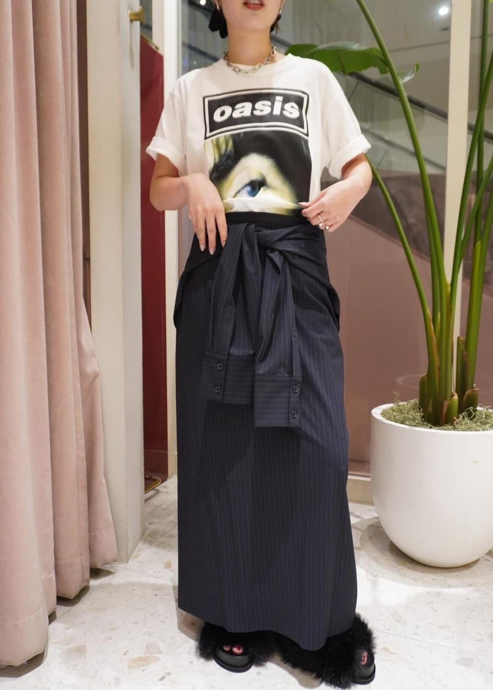 ブルー系のスカート、ブラック系のサンダル、ベージュ系のTシャツ/カットソーを着用したレディースの夏コーディネートの2枚目の写真