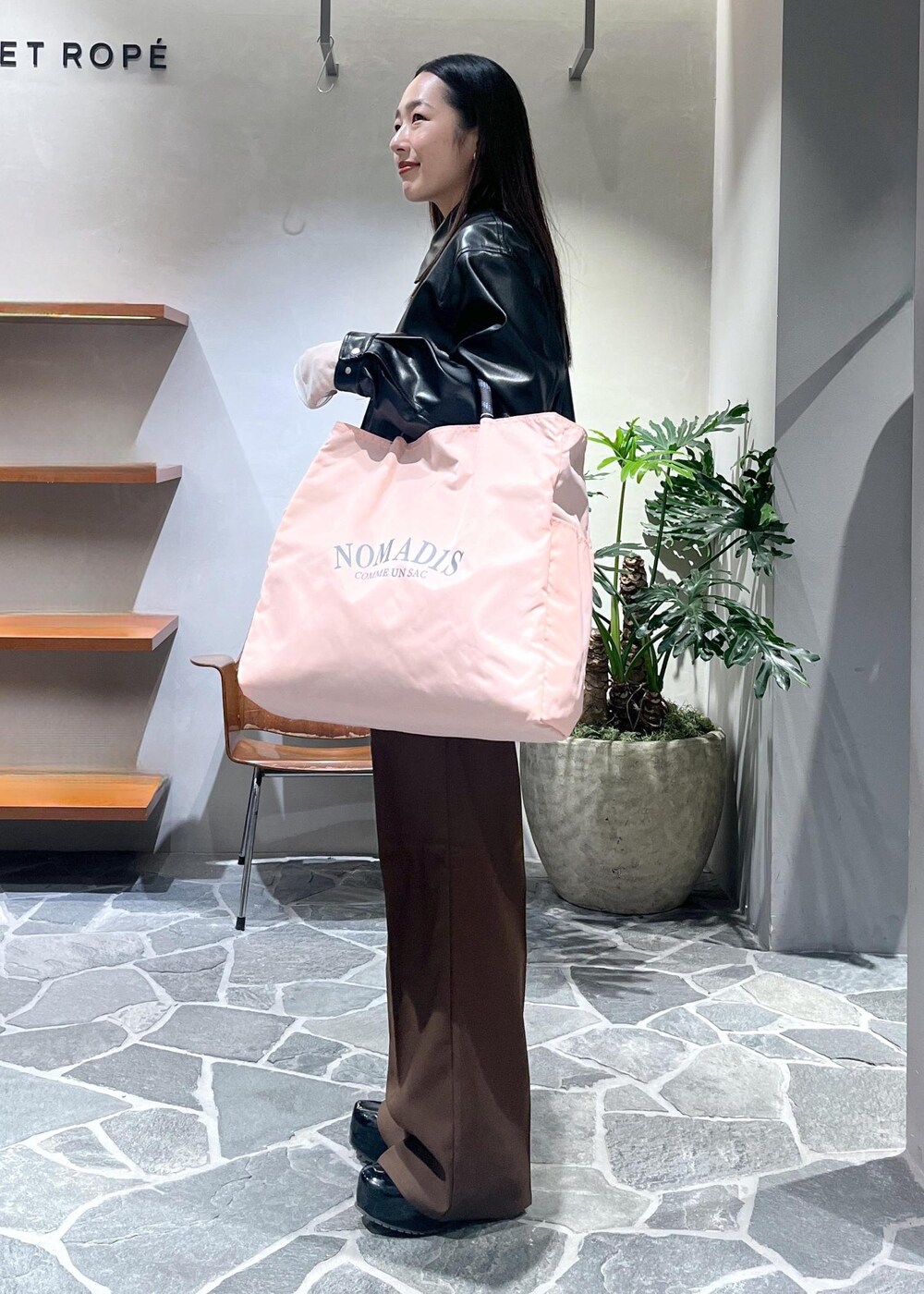 ブラック系のサンダル、ホワイト系のベスト、ブラック系のブルゾンを着用したレディースの春コーディネートの3枚目の写真