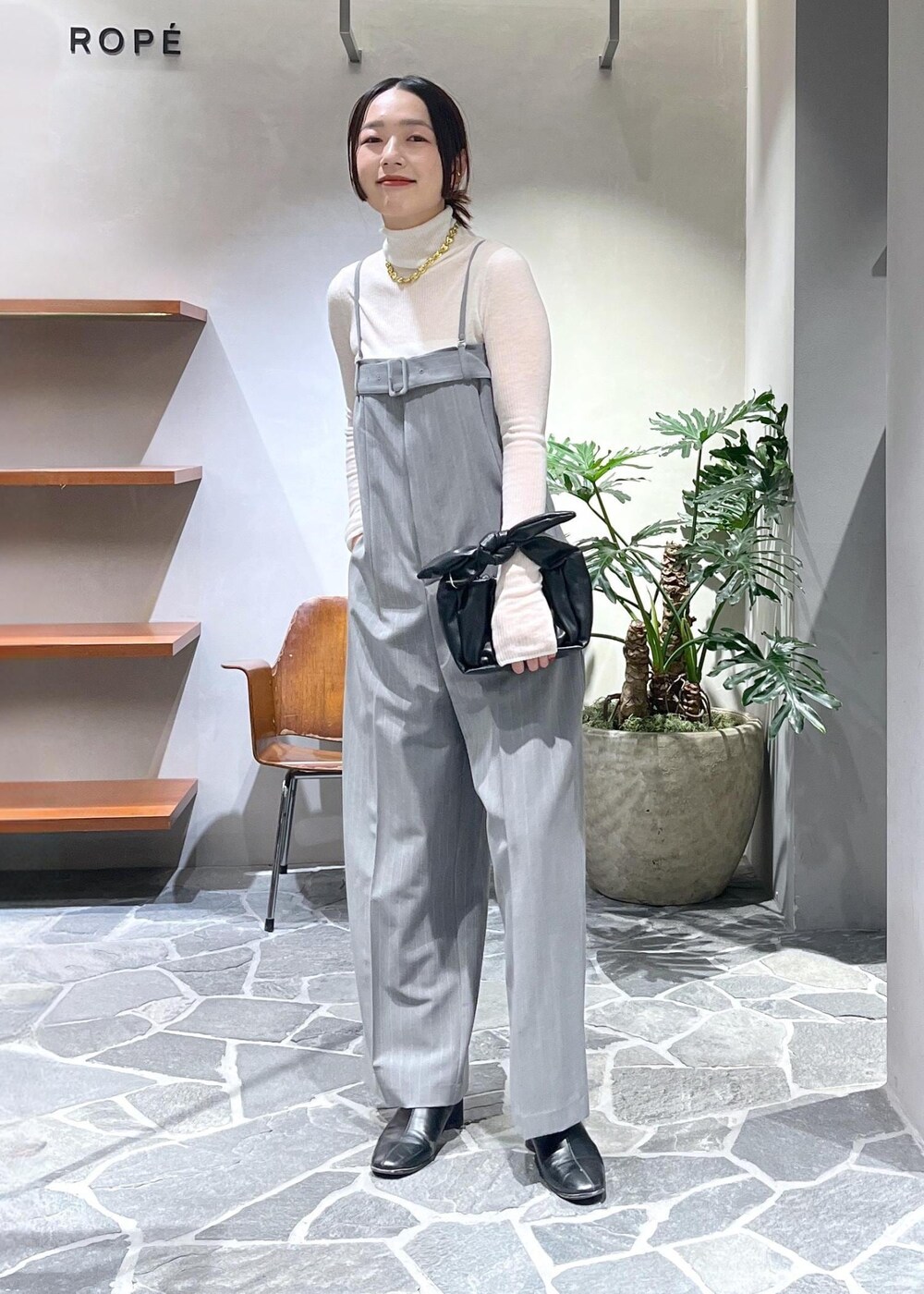 ホワイト系のカーディガン/ボレロ、ホワイト系のニット/セーター、ブラック系のショルダーバッグを着用したレディースの冬コーディネートの4枚目の写真