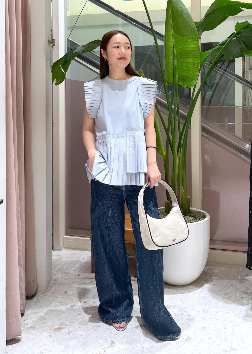 ホワイト系のハンドバッグ、ブルー系のTシャツ/カットソーを着用したレディースの夏コーディネートの3枚目の写真