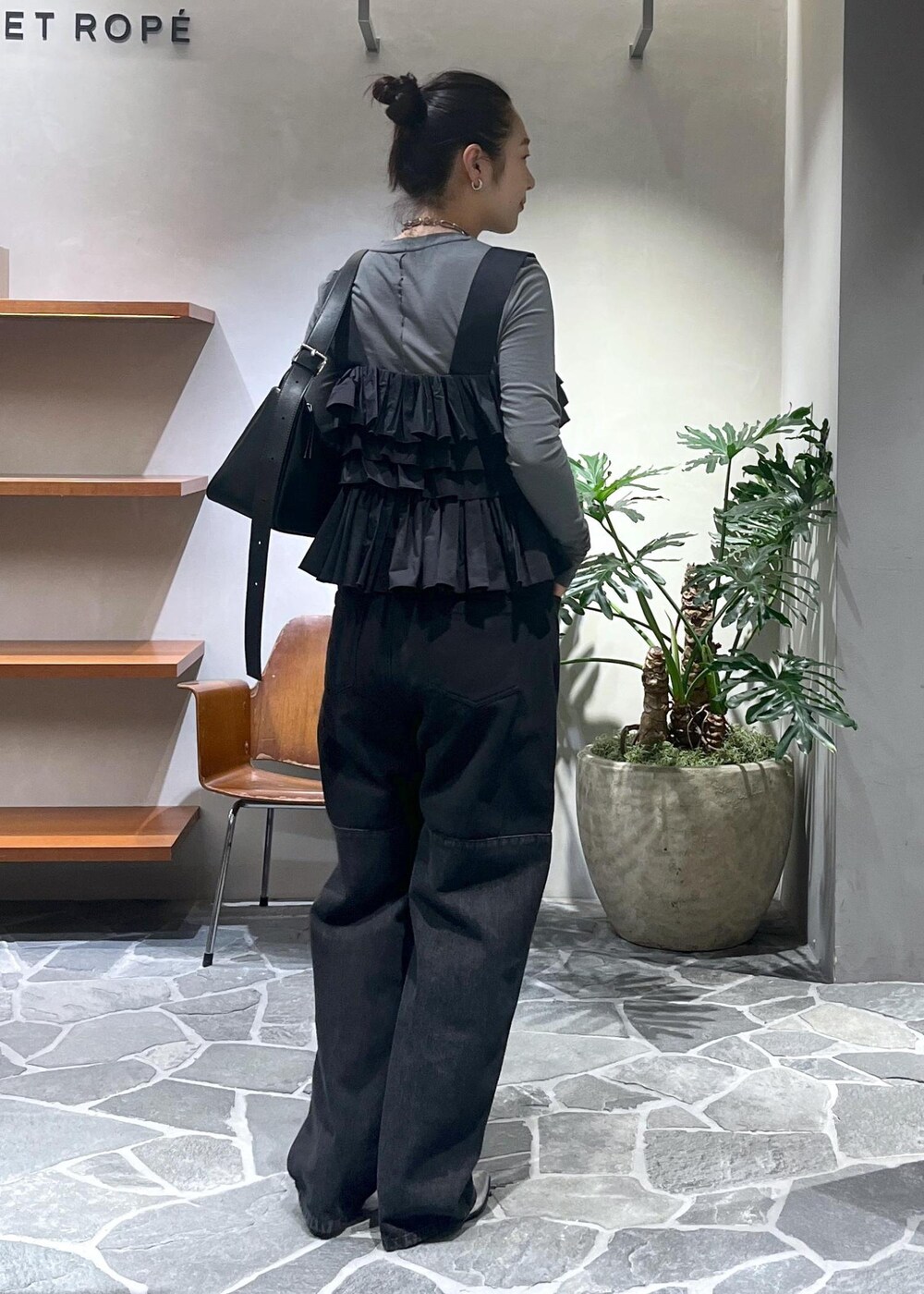 ブラック系のショルダーバッグ、ブラック系のベストを着用したレディースの冬コーディネートの3枚目の写真