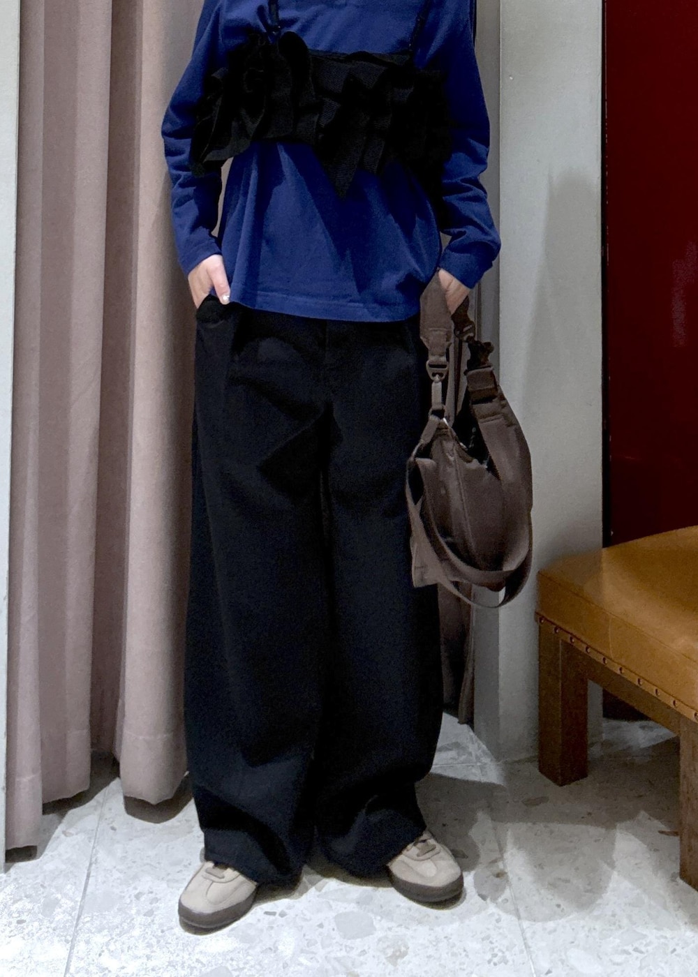 ブラウン系のショルダーバッグ、ブラック系のデニムパンツ、ブラック系のベストを着用したレディースの冬コーディネートの8枚目の写真