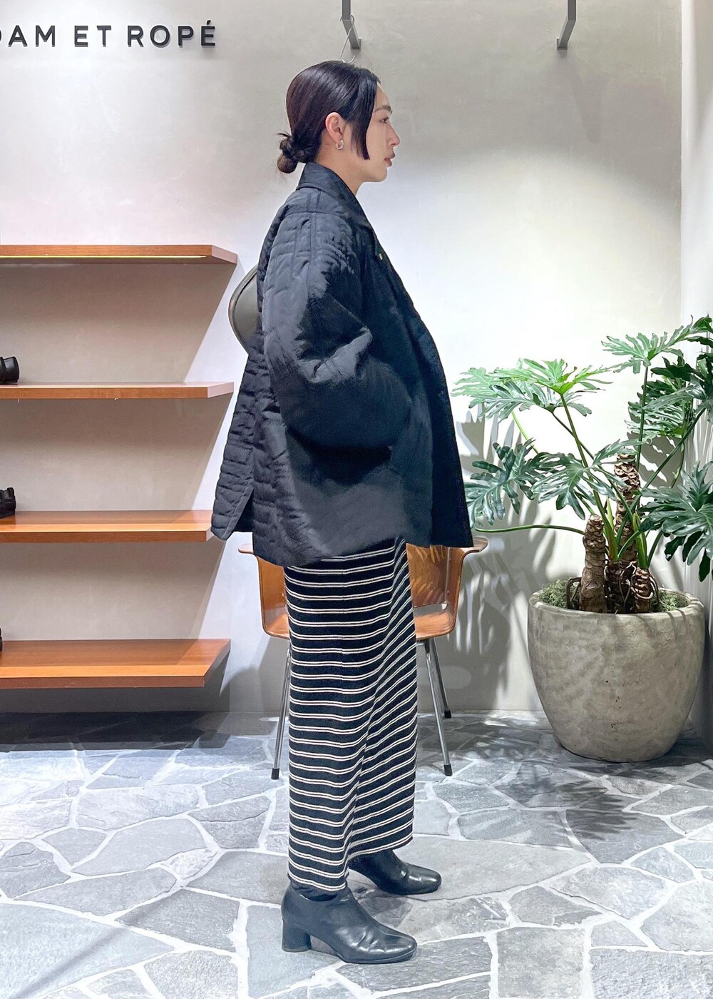 ブラック系のワンピース、グリーン系のショルダーバッグ、ブラック系のブルゾンを着用したレディースの冬コーディネートの2枚目の写真