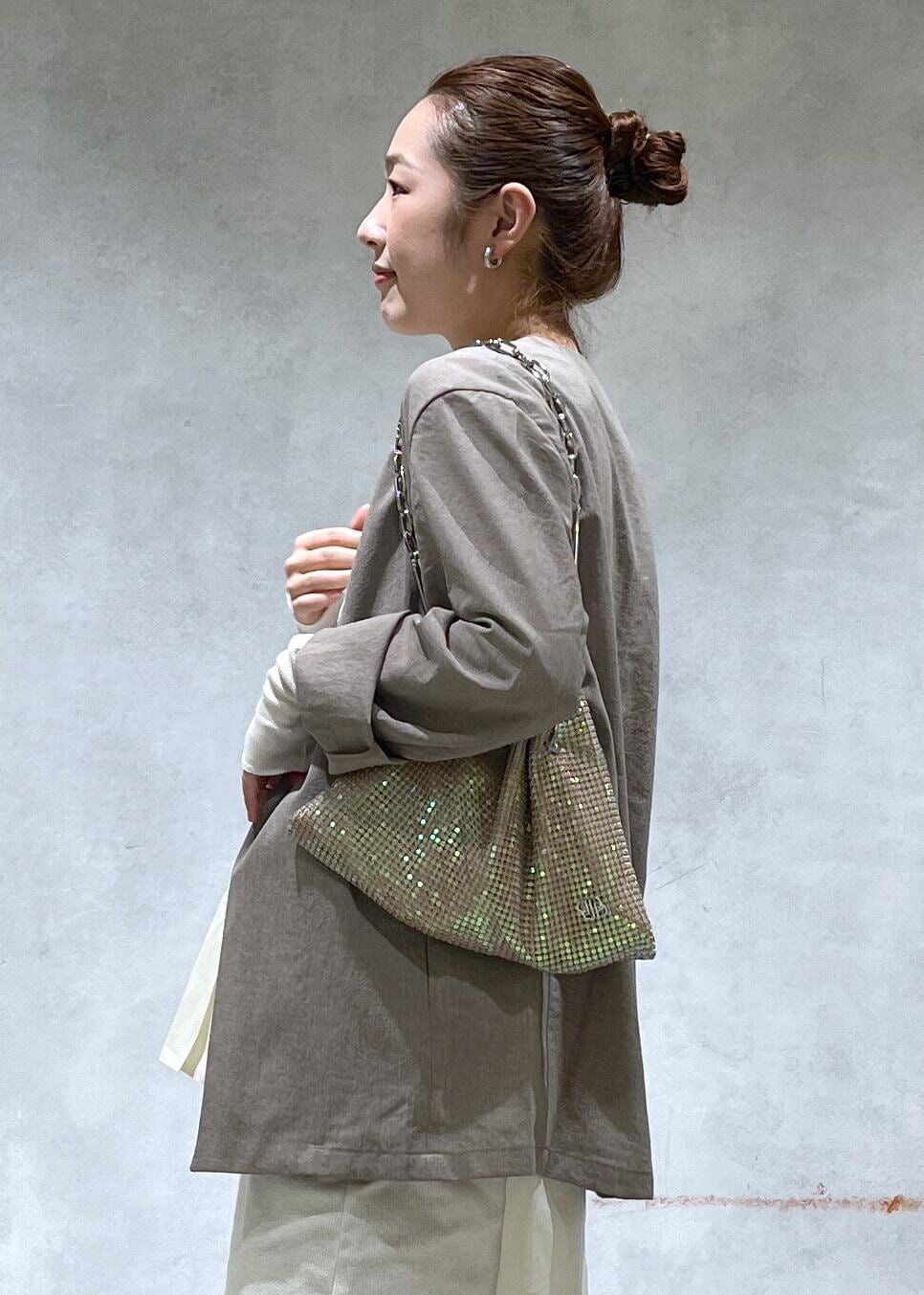 ベージュ系のセットアップ、ブラック系のデニムパンツ、その他のハンドバッグを着用したレディースの春コーディネートの5枚目の写真