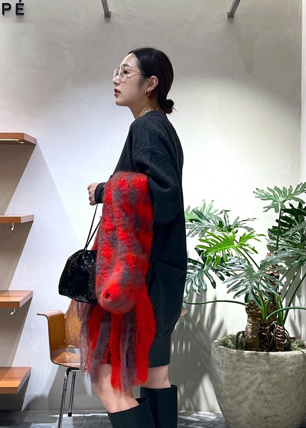 ブラック系のブーツ、グレー系のニット/セーター、ブラック系のハンドバッグを着用したレディースの秋コーディネートの5枚目の写真