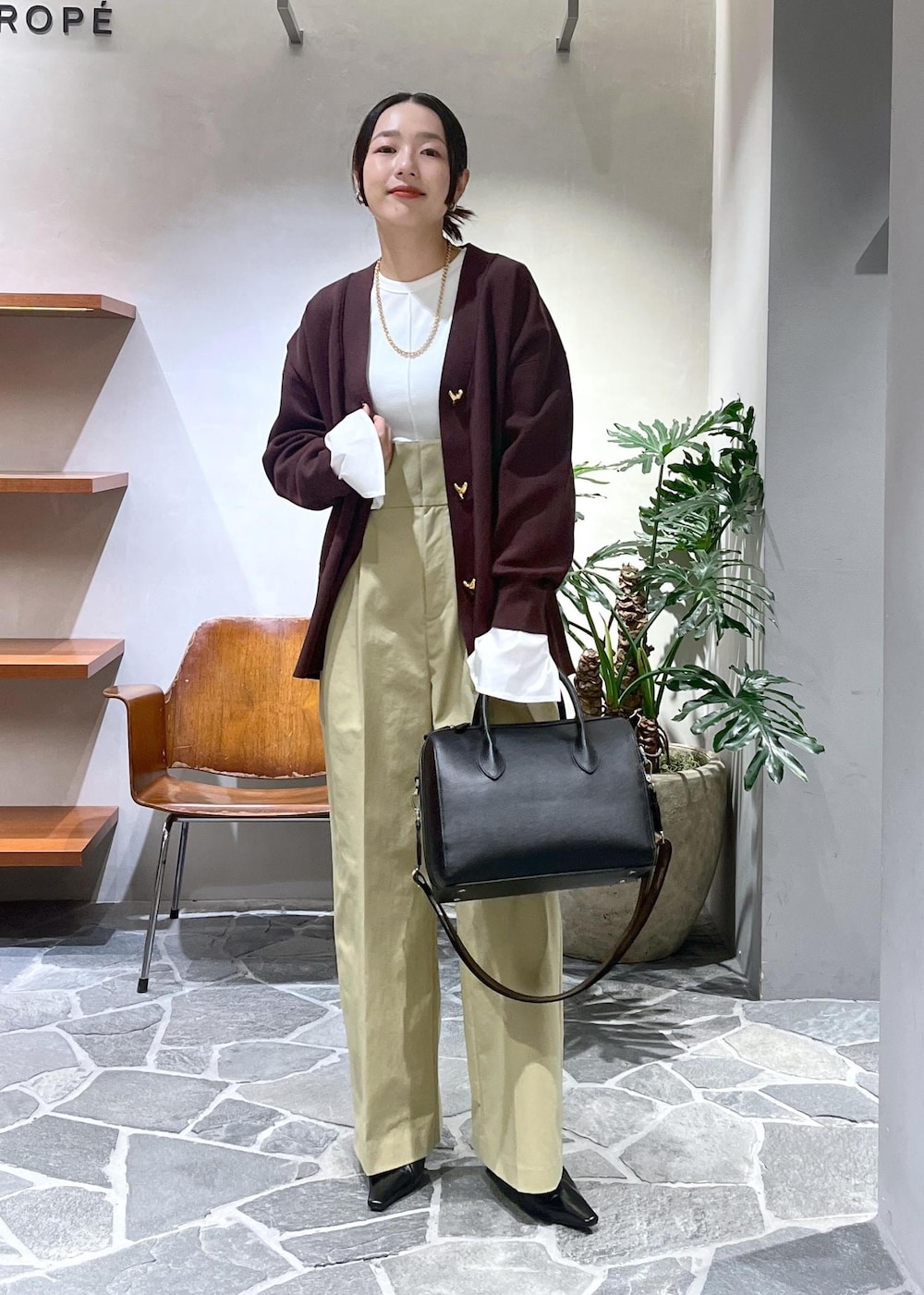 ベージュ系のサロペット/オーバーオール、ホワイト系のTシャツ/カットソー、ブラック系のボストンバッグを着用したレディースの冬コーディネートの2枚目の写真