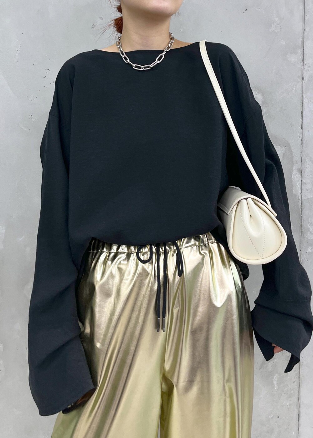 ホワイト系のパンプス、ブラック系のシャツ/ブラウス、ゴールド系のその他パンツを着用したレディースの秋コーディネートの3枚目の写真