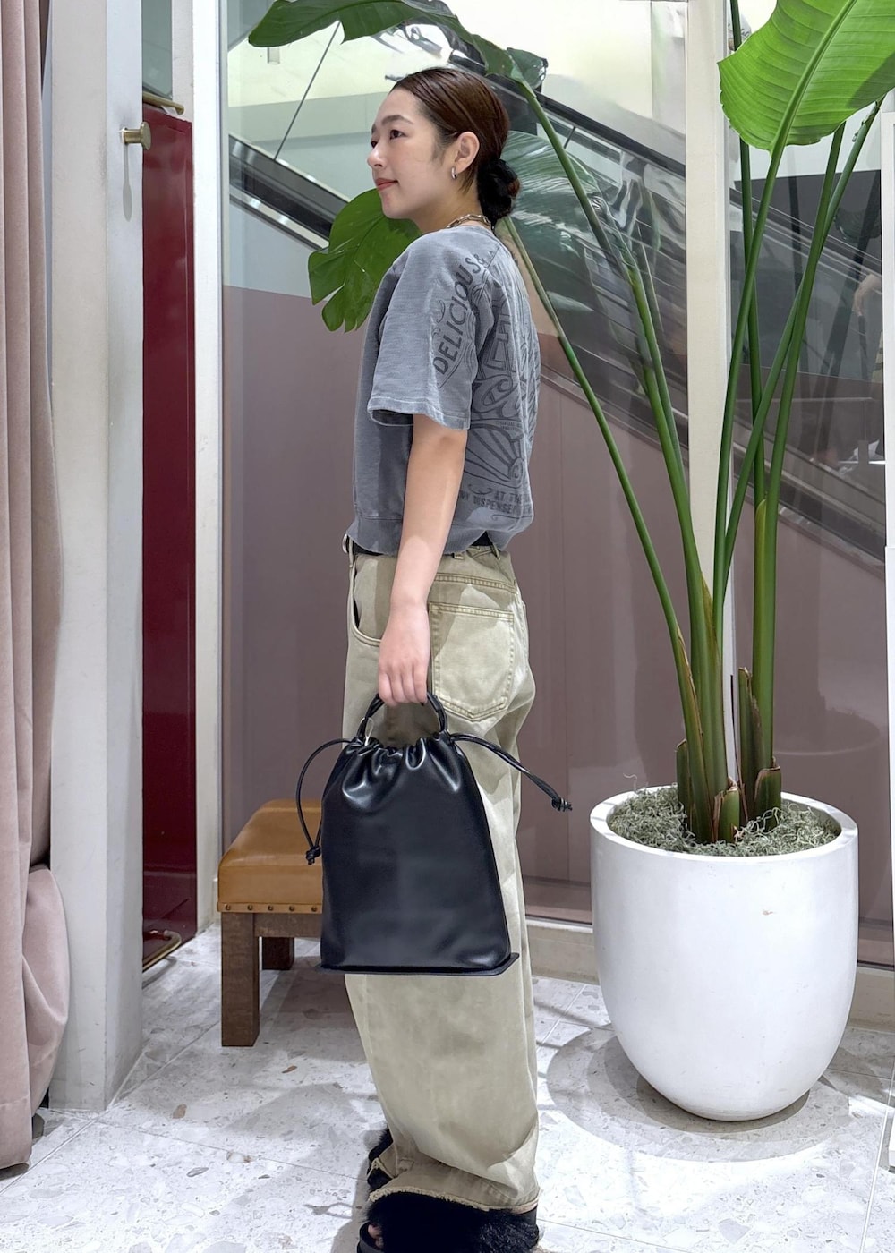 ベージュ系のデニムパンツ、ブラック系のサンダル、ブラック系のショルダーバッグを着用したレディースの夏コーディネートの2枚目の写真