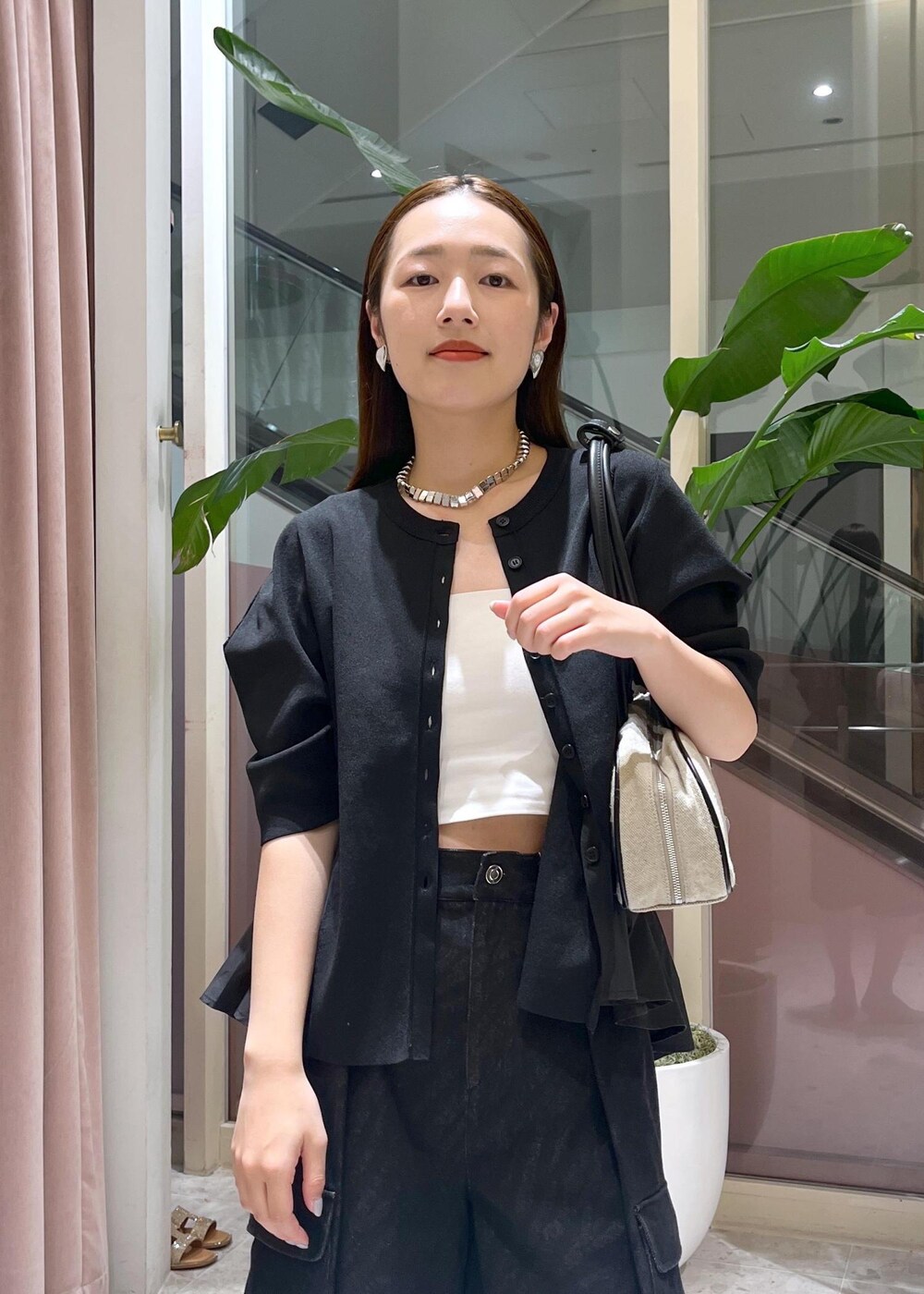 ベージュ系のサンダル、ホワイト系のボストンバッグ、ブラック系のカーディガン/ボレロを着用したレディースの春コーディネートの4枚目の写真