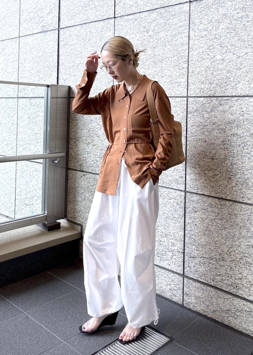 ベージュ系のショルダーバッグ、ブラウン系のカーディガン/ボレロを着用したレディースの春コーディネートの2枚目の写真