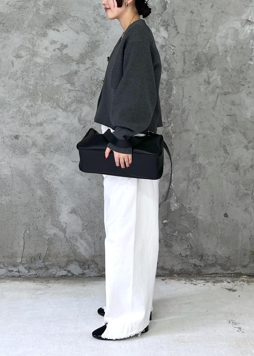 ブラック系のパンプス、ホワイト系のデニムパンツ、グレー系のカーディガン/ボレロを着用したレディースの冬コーディネートの3枚目の写真