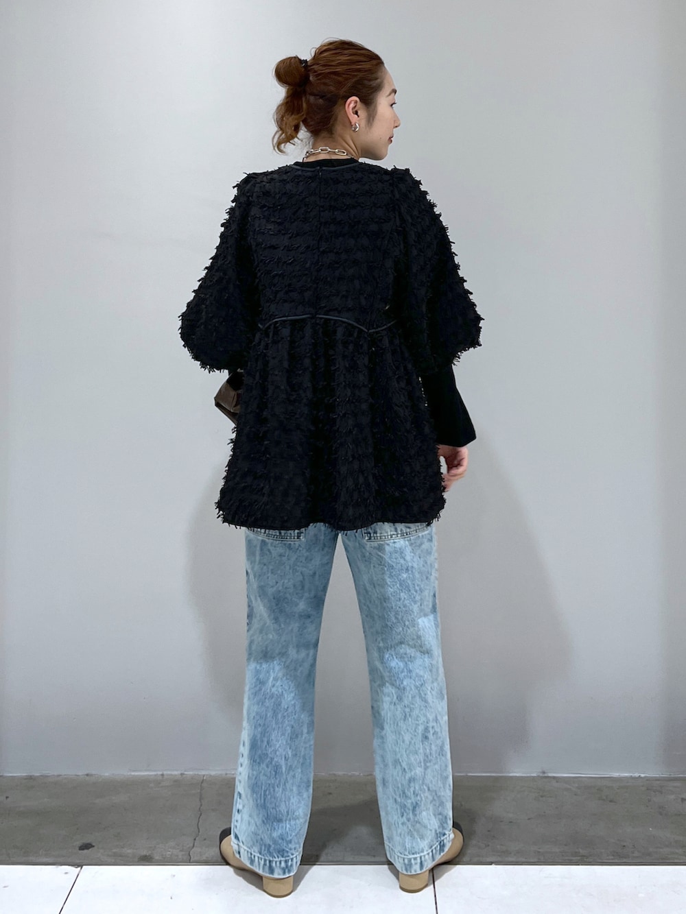 ブラック系のシャツ/ブラウス、ブルー系のデニムパンツ、ベージュ系のパンプスを着用したレディースの冬コーディネートの3枚目の写真