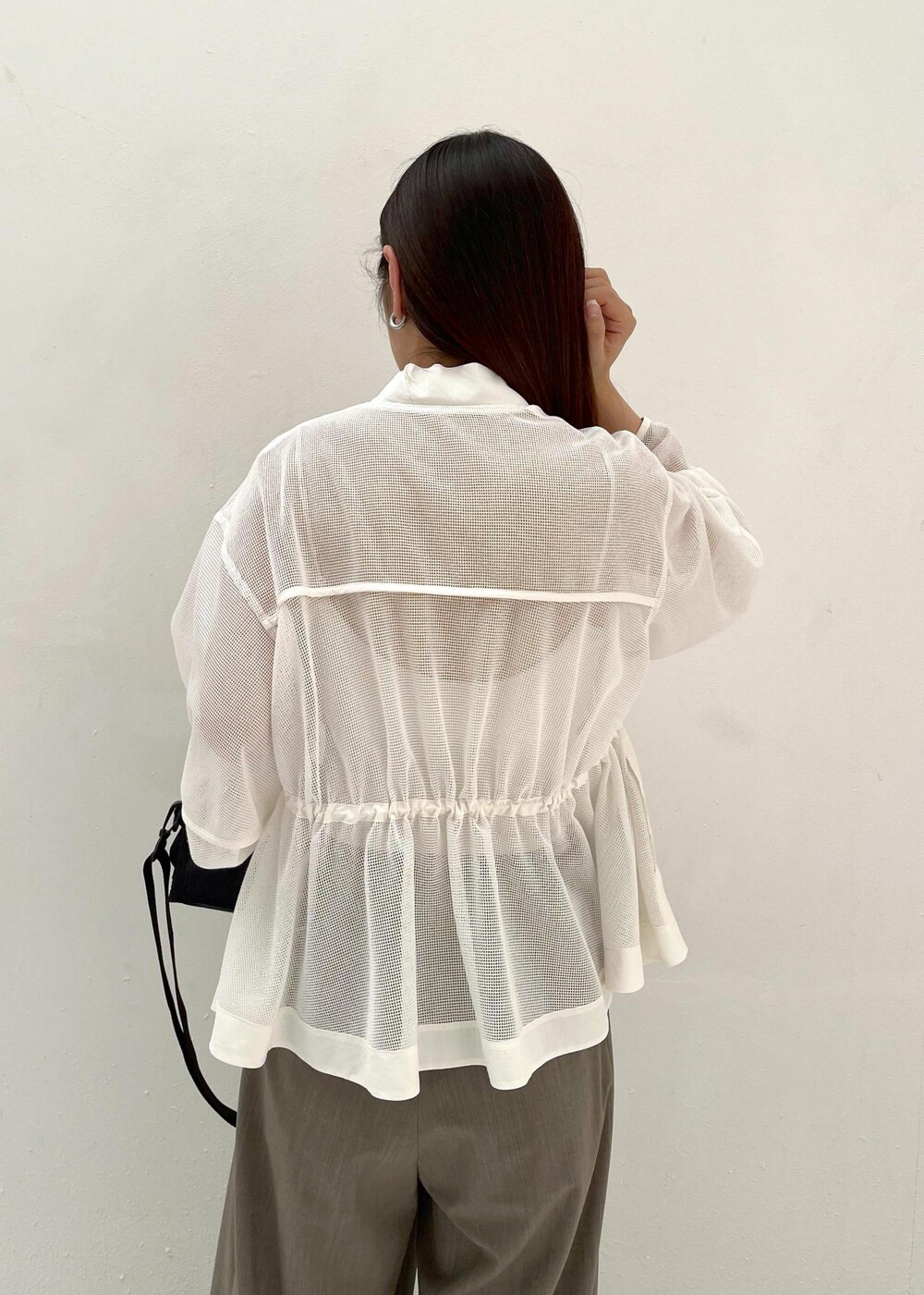 グレー系のスラックス、ホワイト系のカーディガン/ボレロを着用したレディースの春コーディネートの5枚目の写真