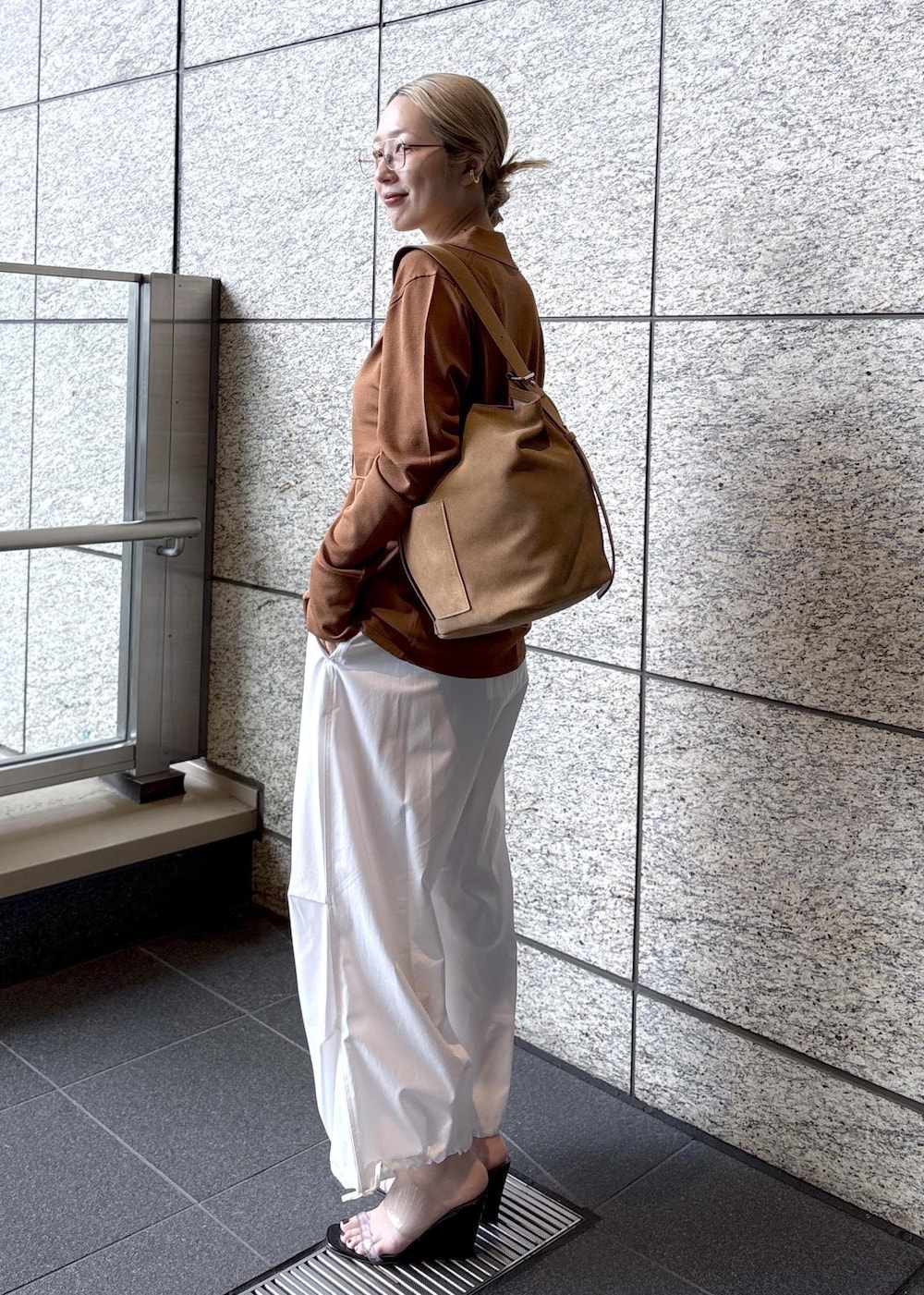 ベージュ系のショルダーバッグ、ブラウン系のカーディガン/ボレロを着用したレディースの春コーディネートの3枚目の写真