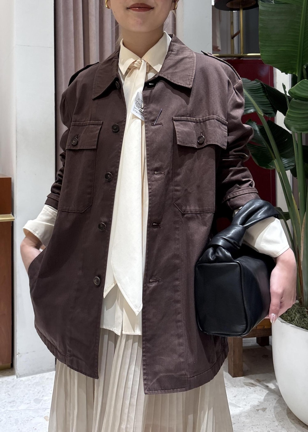 ブラック系のハンドバッグ、ホワイト系のシャツ/ブラウスを着用したレディースの春コーディネートの3枚目の写真