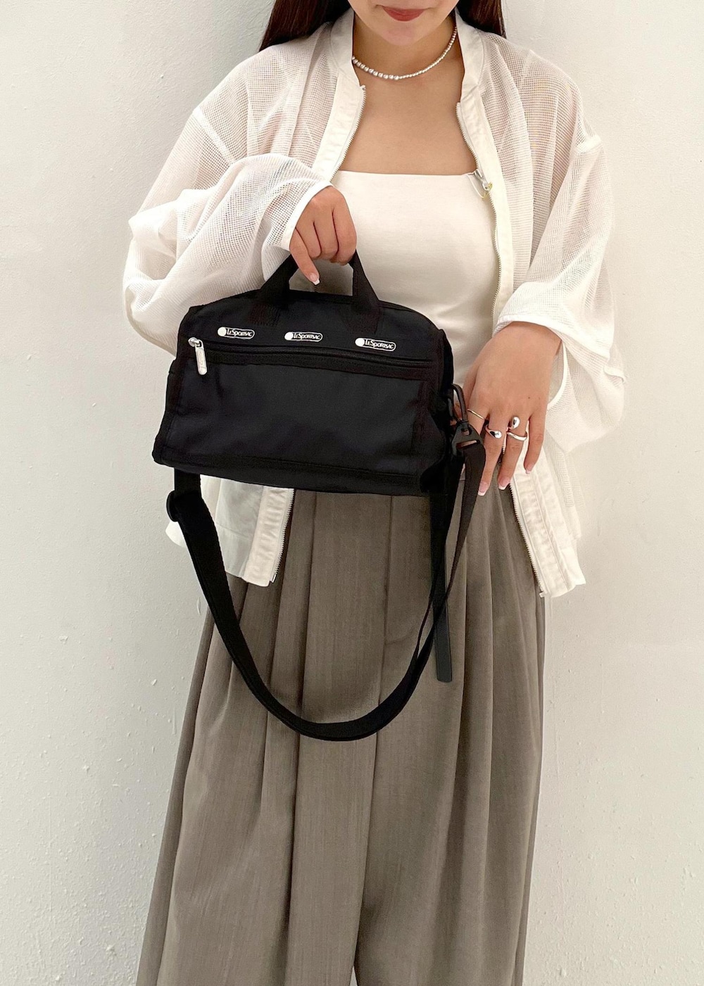 グレー系のスラックス、ホワイト系のカーディガン/ボレロを着用したレディースの春コーディネートの4枚目の写真