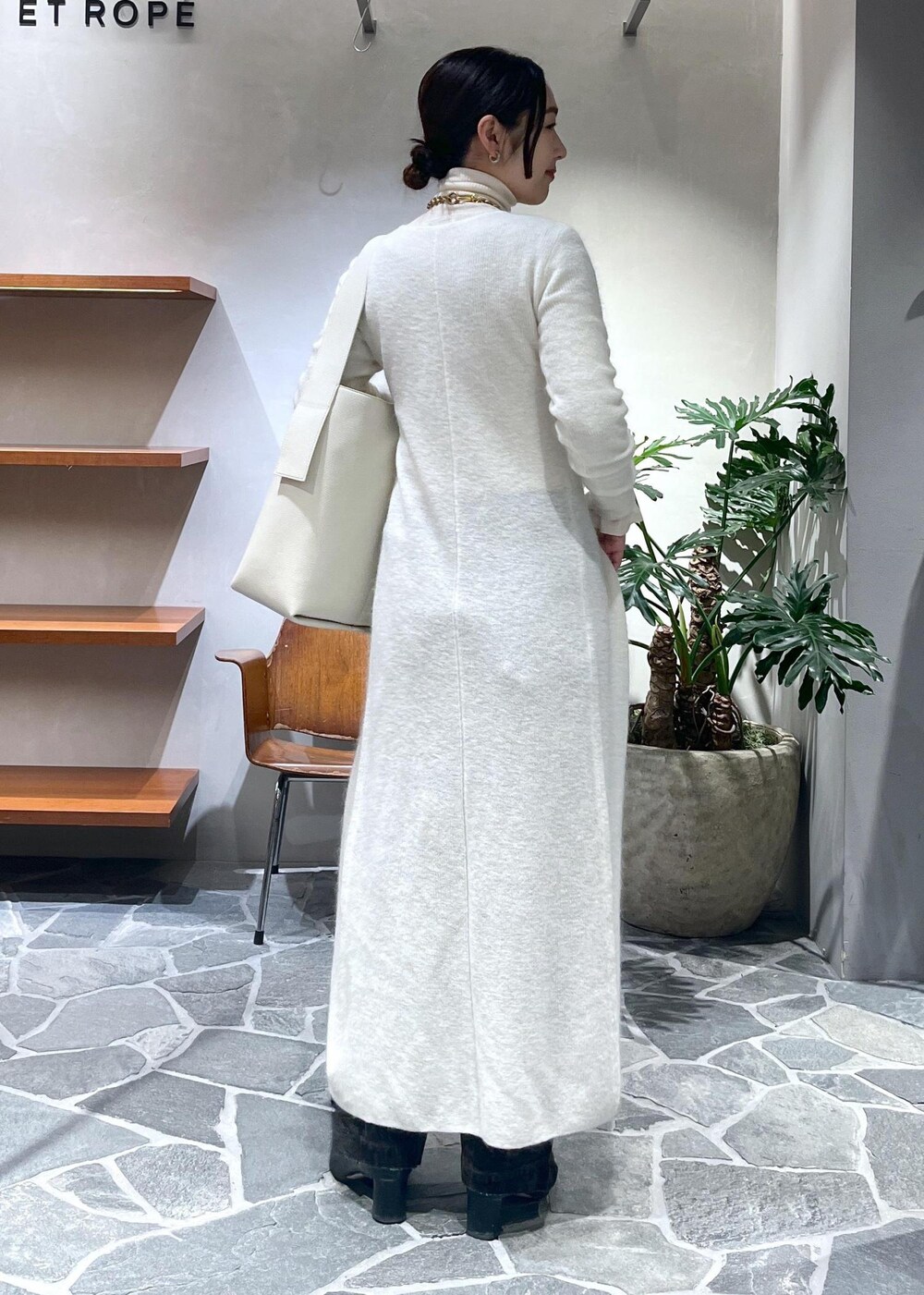 ホワイト系のカーディガン/ボレロ、ブラウン系のデニムパンツを着用したレディースの冬コーディネートの5枚目の写真