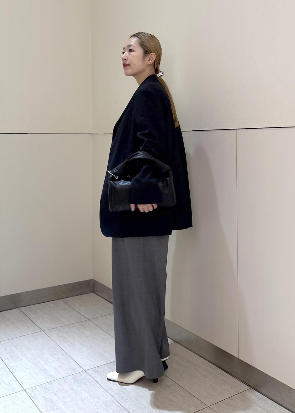 ホワイト系のパンプス、ブラック系のテーラードジャケット、ブルー系のつなぎ/オールインワンを着用したレディースの冬コーディネートの2枚目の写真