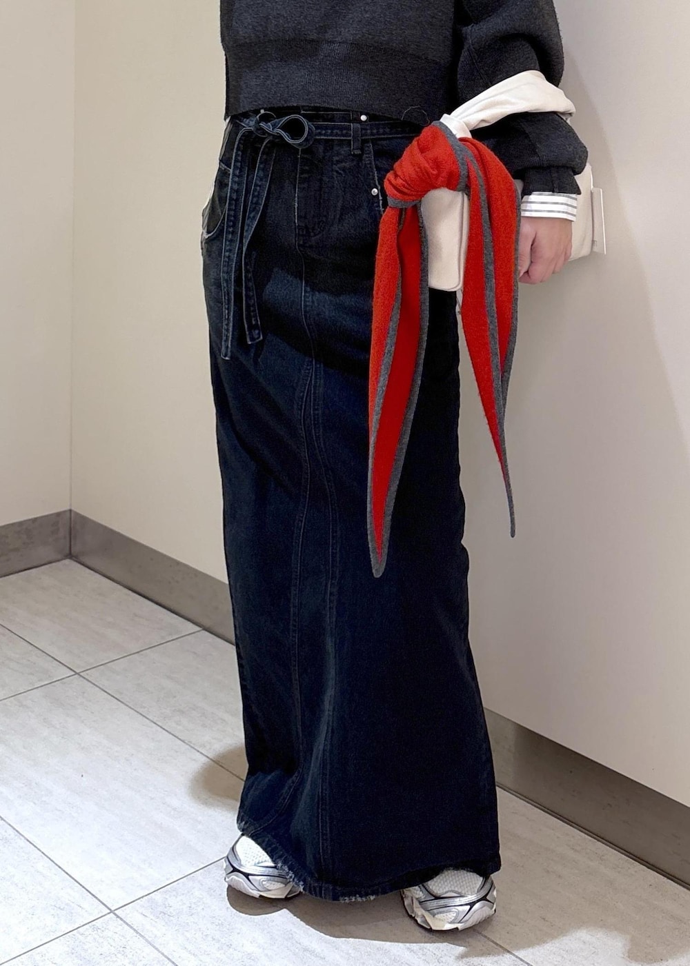 ホワイト系のスニーカー、グレー系のニット/セーター、ホワイト系のハンドバッグを着用したレディースの冬コーディネートの4枚目の写真