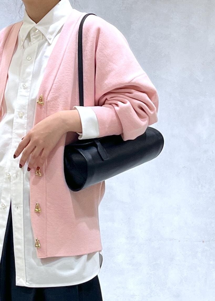 ブラック系のショルダーバッグ、ブラック系のブーツ、ピンク系のカーディガン/ボレロを着用したレディースの秋コーディネートの6枚目の写真