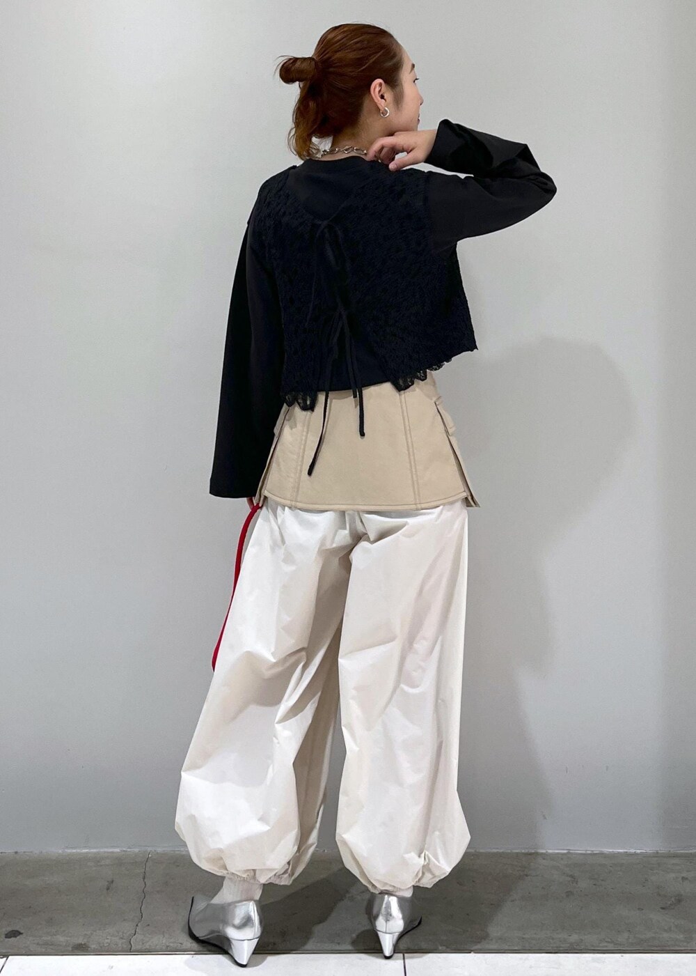 ブラック系のTシャツ/カットソー、ブラック系のベスト、ホワイト系のその他パンツを着用したレディースの冬コーディネートの3枚目の写真