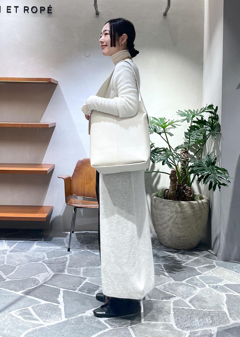 ホワイト系のカーディガン/ボレロ、ブラウン系のデニムパンツを着用したレディースの冬コーディネートの4枚目の写真