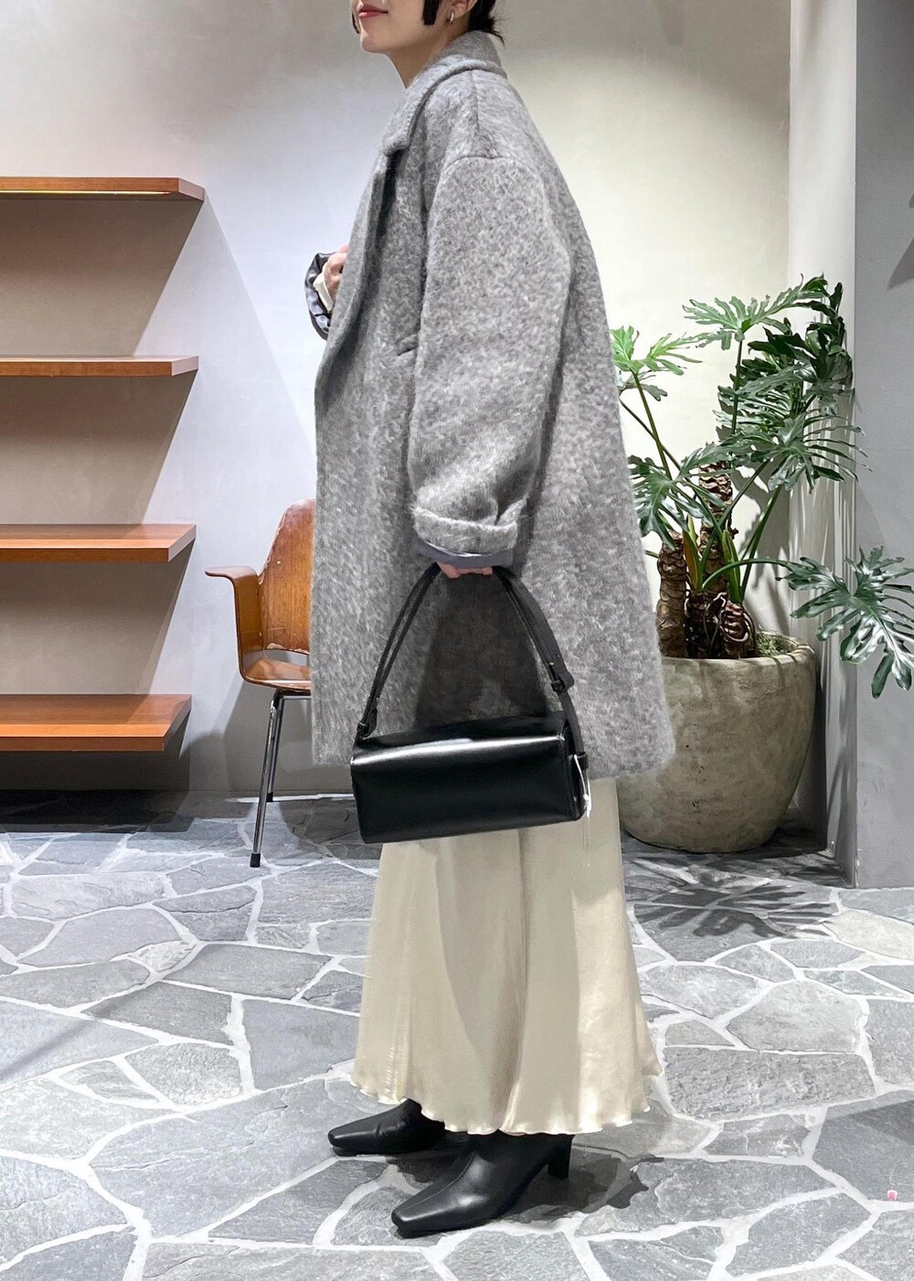 ブラック系のブーツ、ベージュ系のスカート、ブラック系のカーディガン/ボレロを着用したレディースの冬コーディネートの5枚目の写真