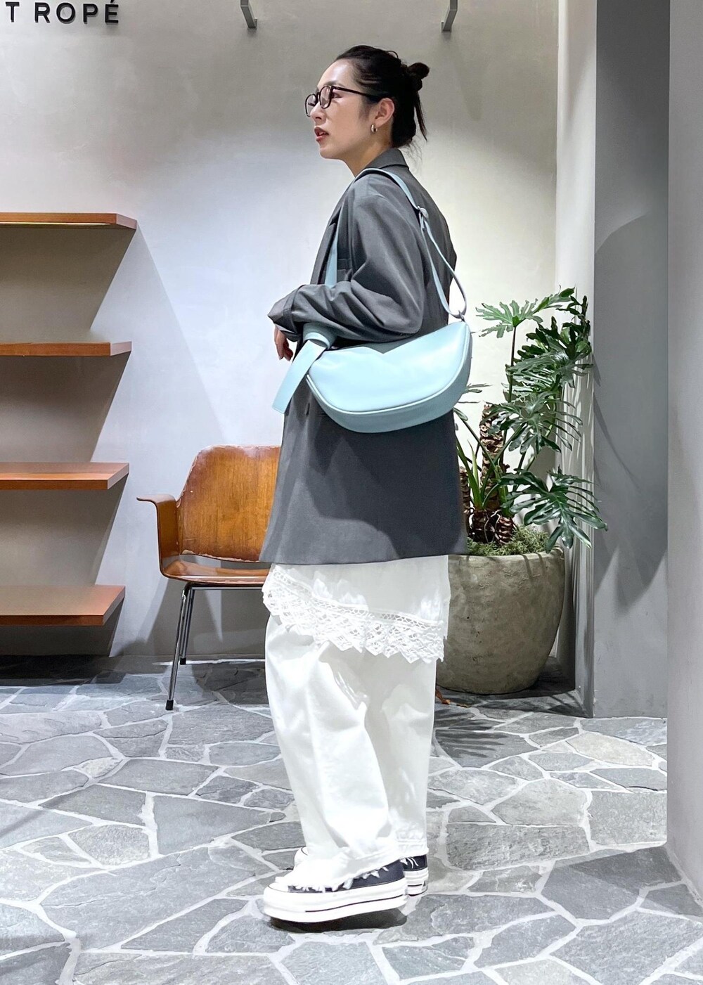 ブルー系のショルダーバッグ、ホワイト系のデニムパンツ、ホワイト系のスカートを着用したレディースの冬コーディネートの2枚目の写真