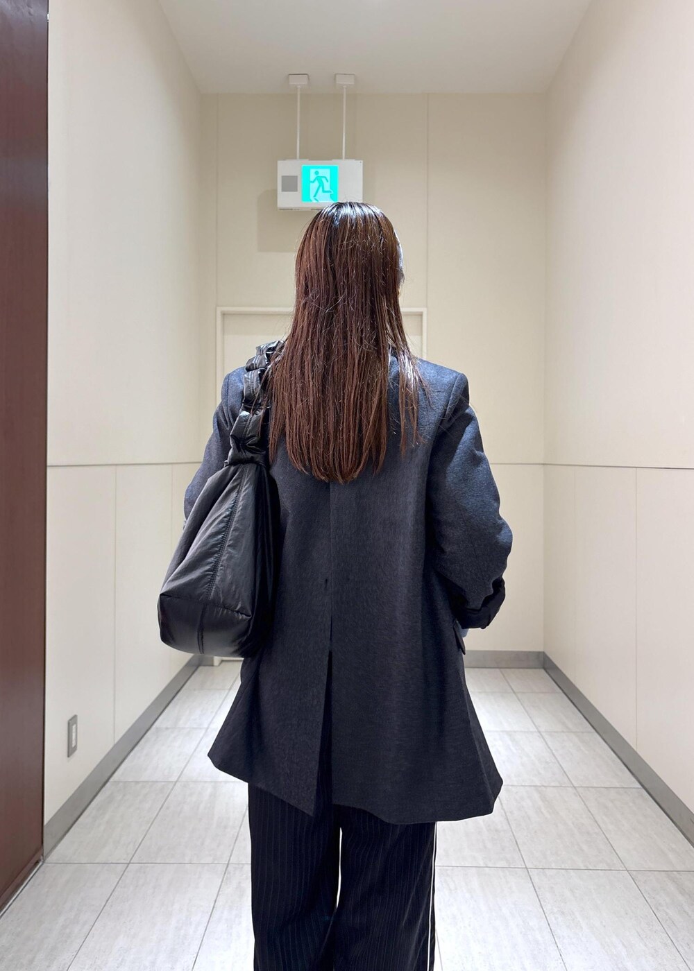 ブルー系のスウェット、ブラウン系のサンダル、グレー系のテーラードジャケットを着用したレディースの秋コーディネートの5枚目の写真