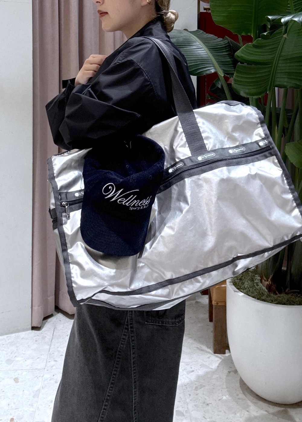 シルバー系のボストンバッグ、ブラック系のナイロンジャケット、ブラック系のサロペット/オーバーオールを着用したレディースの春コーディネートの3枚目の写真