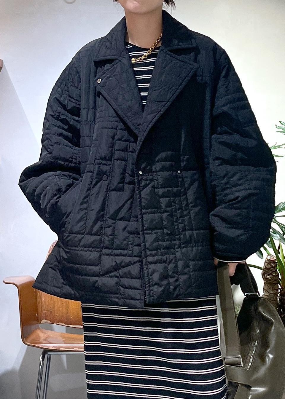 ブラック系のワンピース、グリーン系のショルダーバッグ、ブラック系のブルゾンを着用したレディースの冬コーディネートの3枚目の写真