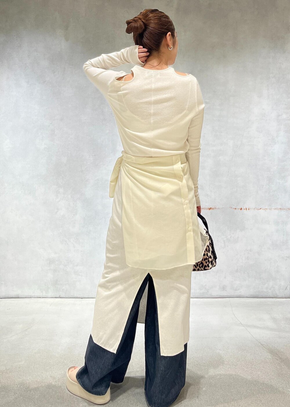 ブラック系のデニムパンツ、ホワイト系のシャツ/ブラウス、ホワイト系のワンピースを着用したレディースの春コーディネートの3枚目の写真