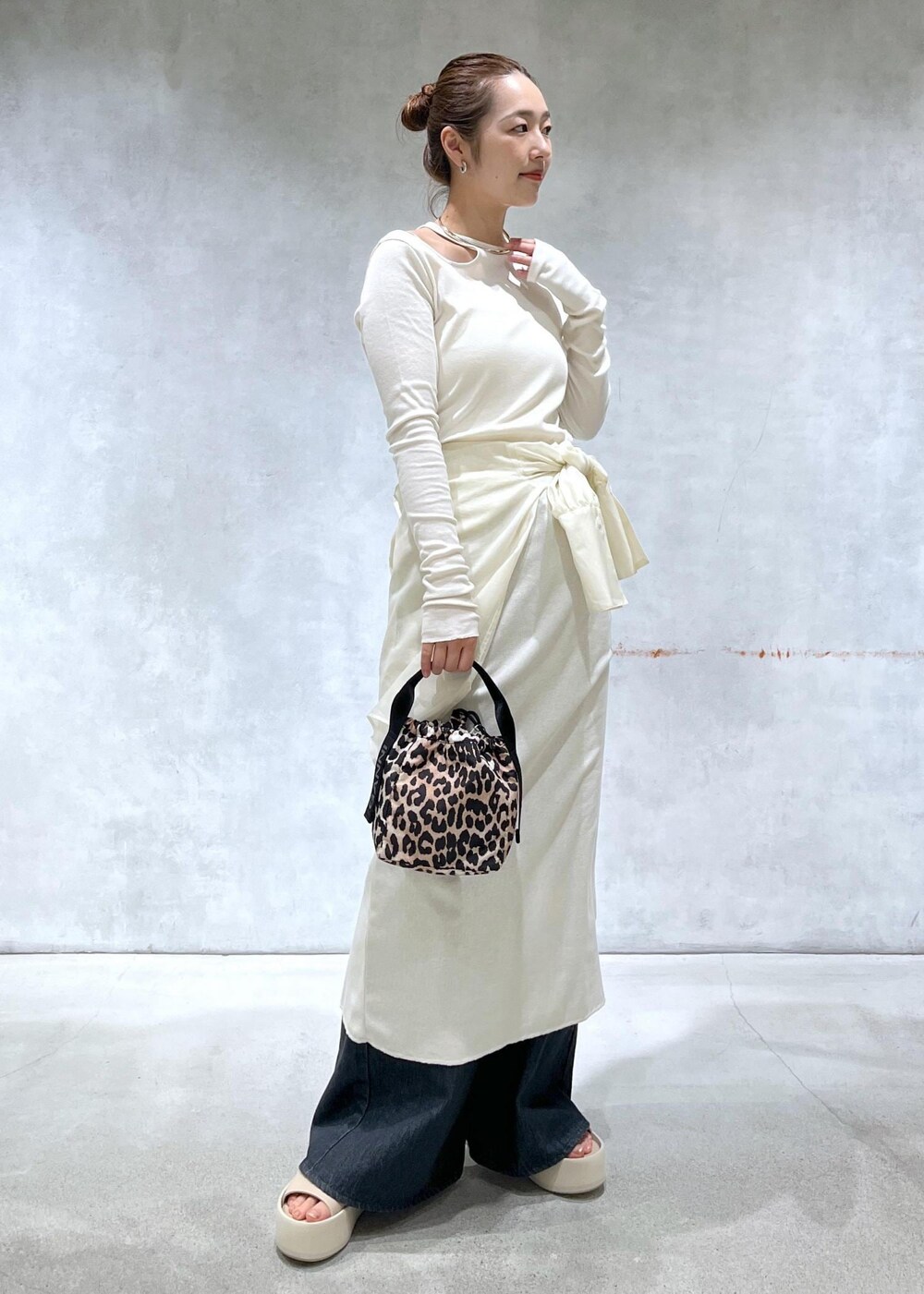 ブラック系のデニムパンツ、ホワイト系のシャツ/ブラウス、ホワイト系のワンピースを着用したレディースの春コーディネートの2枚目の写真