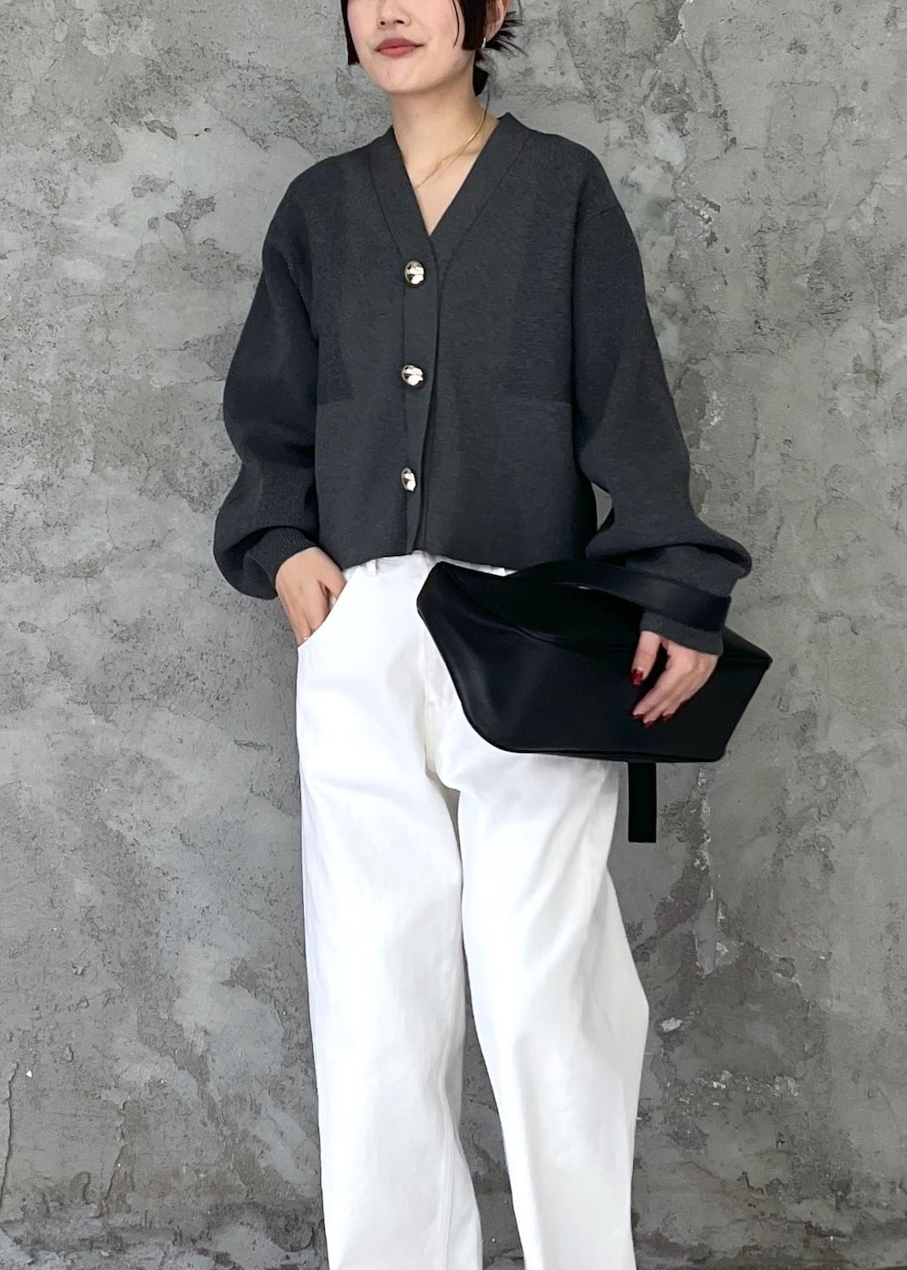 ブラック系のパンプス、ホワイト系のデニムパンツ、グレー系のカーディガン/ボレロを着用したレディースの冬コーディネートの4枚目の写真