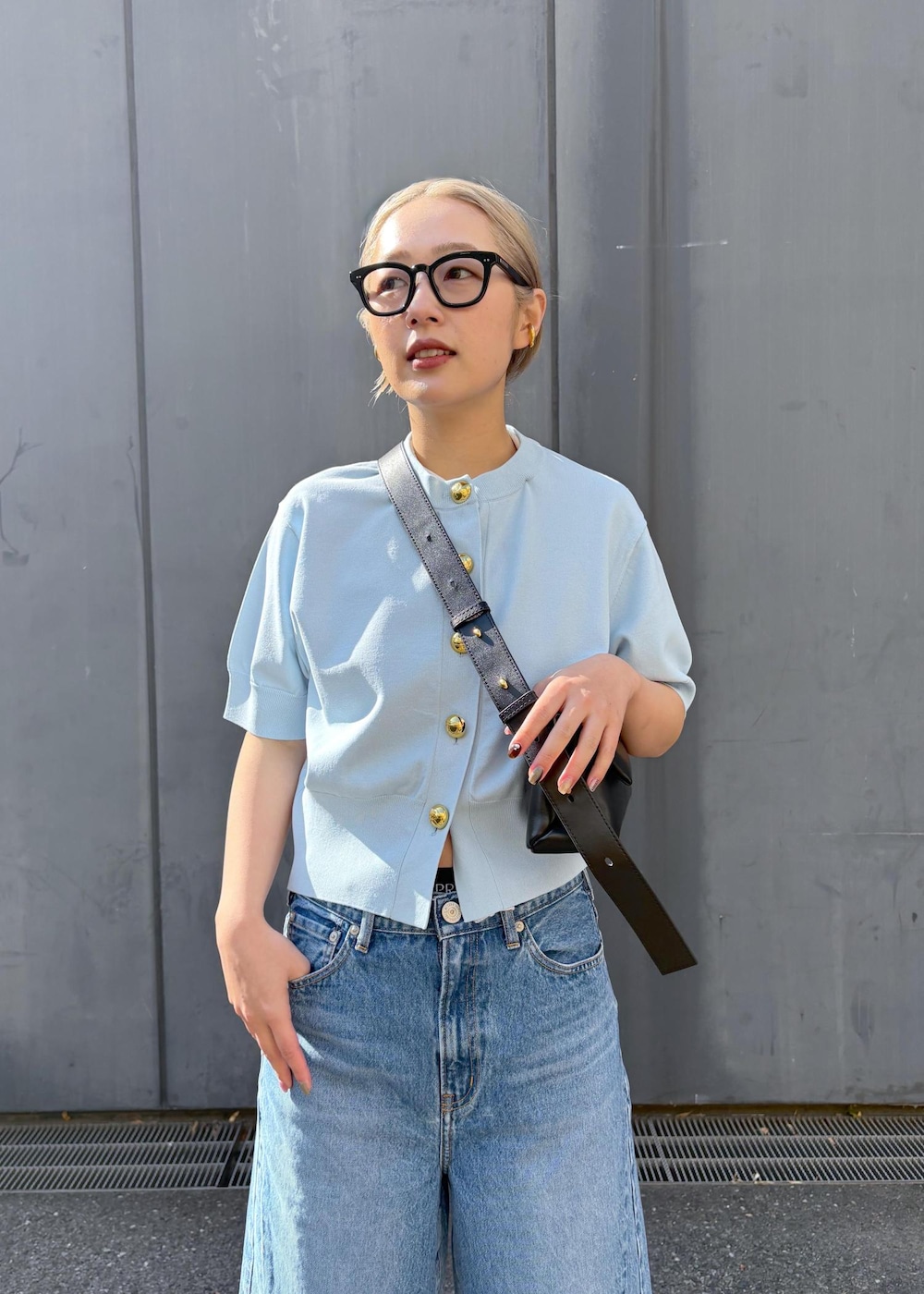 ブラック系のショルダーバッグ、グレー系のスラックスを着用したレディースの冬コーディネートの3枚目の写真