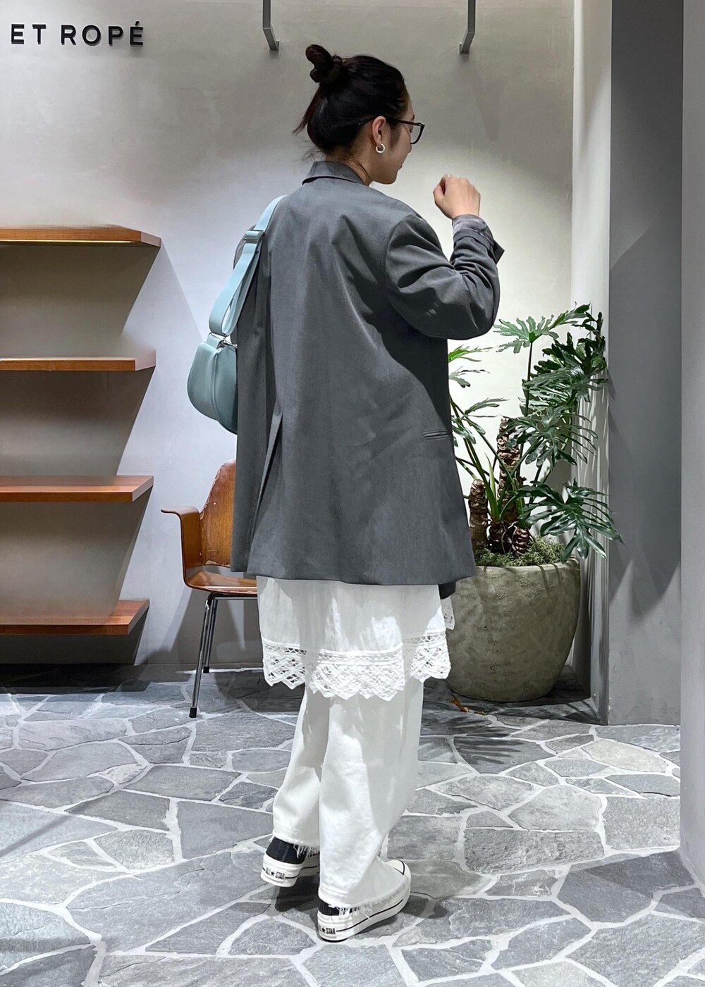 ブルー系のショルダーバッグ、ホワイト系のデニムパンツ、ホワイト系のスカートを着用したレディースの冬コーディネートの3枚目の写真