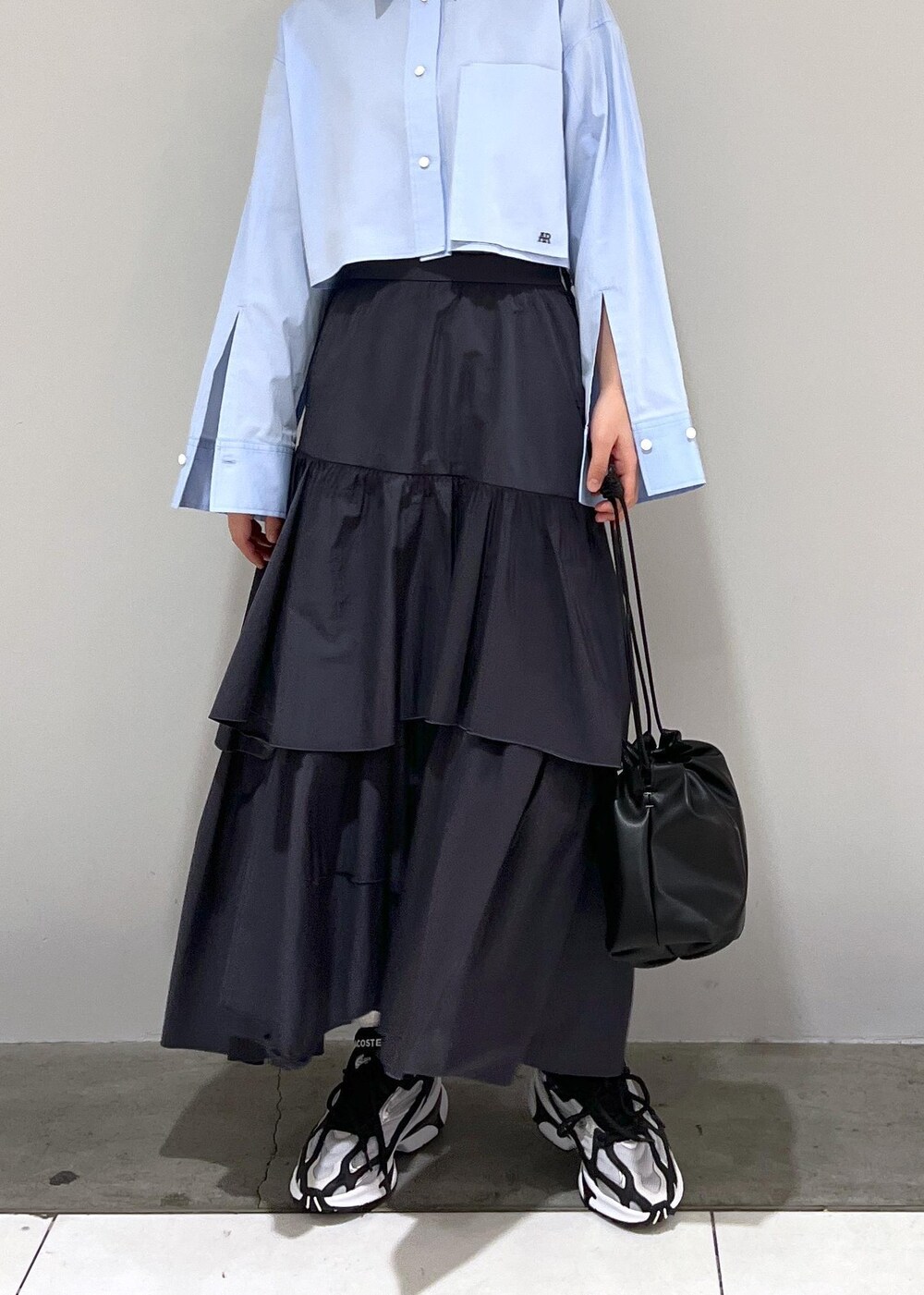ブルー系のシャツ/ブラウス、ブラック系のショルダーバッグ、ブラック系のスカートを着用したレディースの春コーディネートの6枚目の写真