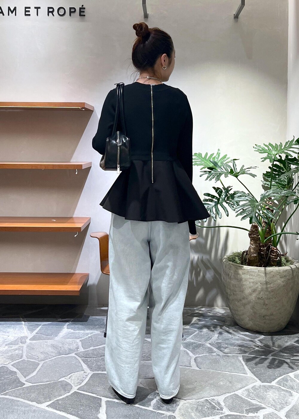 ブラック系のブーツ、ブルー系のその他パンツ、ブラック系のニット/セーターを着用したレディースの秋コーディネートの2枚目の写真