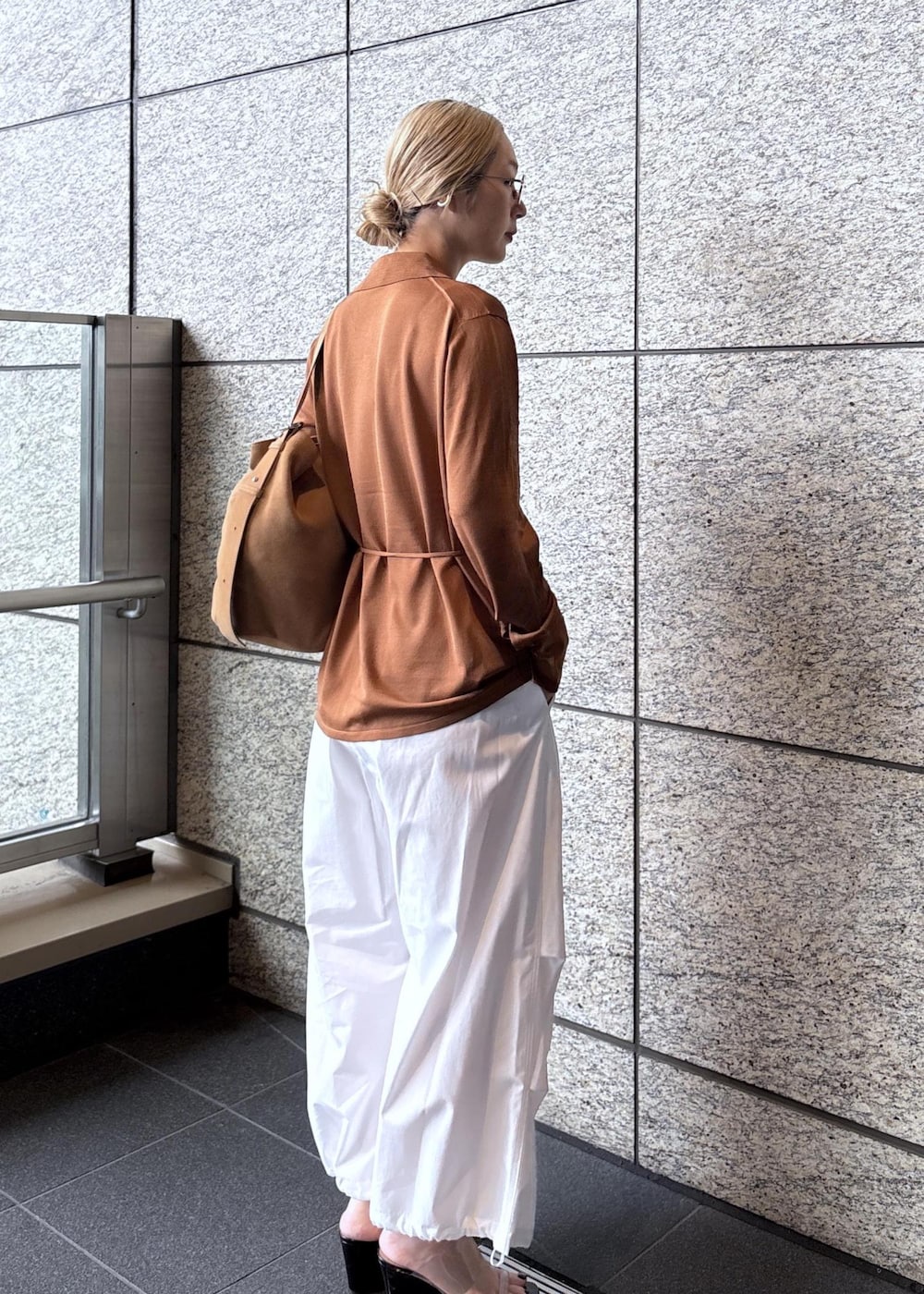 ベージュ系のショルダーバッグ、ブラウン系のカーディガン/ボレロを着用したレディースの春コーディネートの4枚目の写真