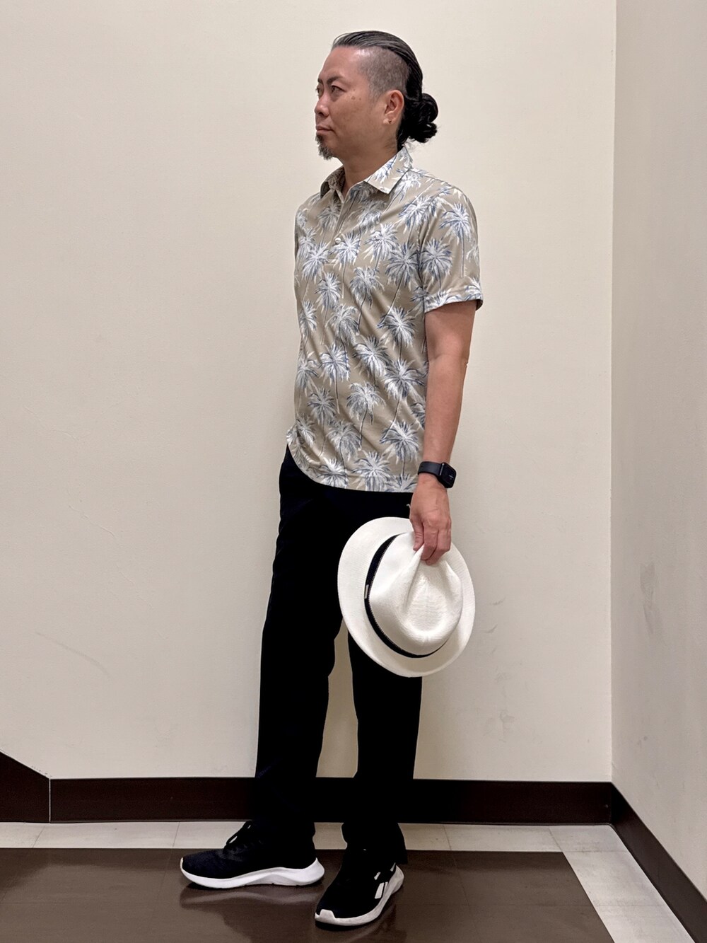ベージュ系のポロシャツ、ブラック系のその他パンツ、ブラック系のキャップを着用したメンズの夏コーディネートの4枚目の写真