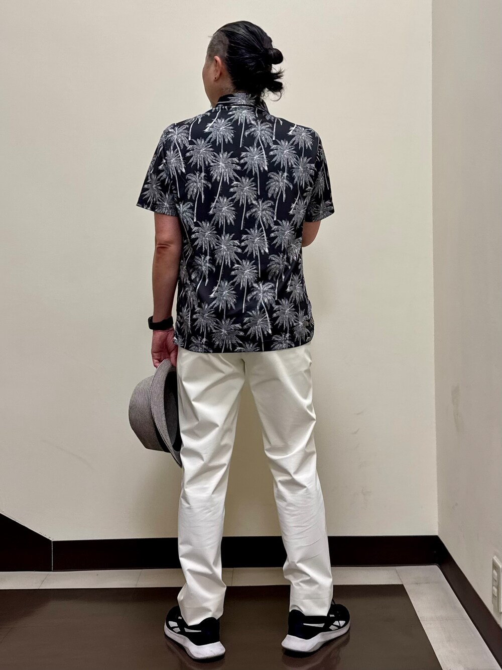 ブラック系のポロシャツ、ホワイト系のその他パンツを着用したメンズの夏コーディネートの5枚目の写真