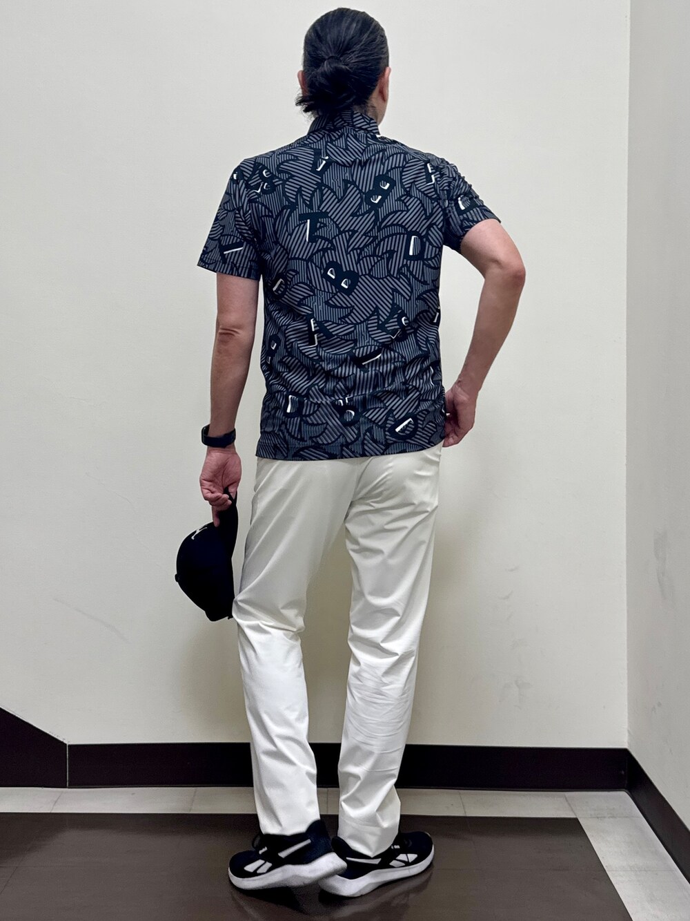 ブラック系のポロシャツ、ホワイト系のその他パンツ、ブラック系のキャップを着用したメンズの夏コーディネートの3枚目の写真