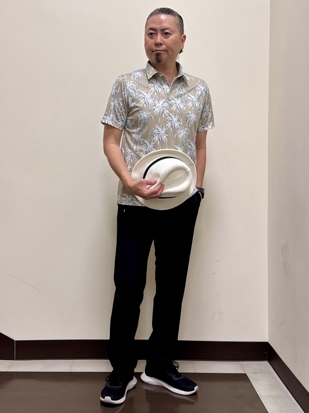 ベージュ系のポロシャツ、ブラック系のその他パンツ、ブラック系のキャップを着用したメンズの夏コーディネートの3枚目の写真