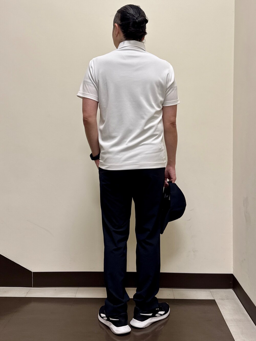 ホワイト系のポロシャツ、ブラック系のその他パンツ、ブラック系のキャップを着用したメンズの夏コーディネートの4枚目の写真