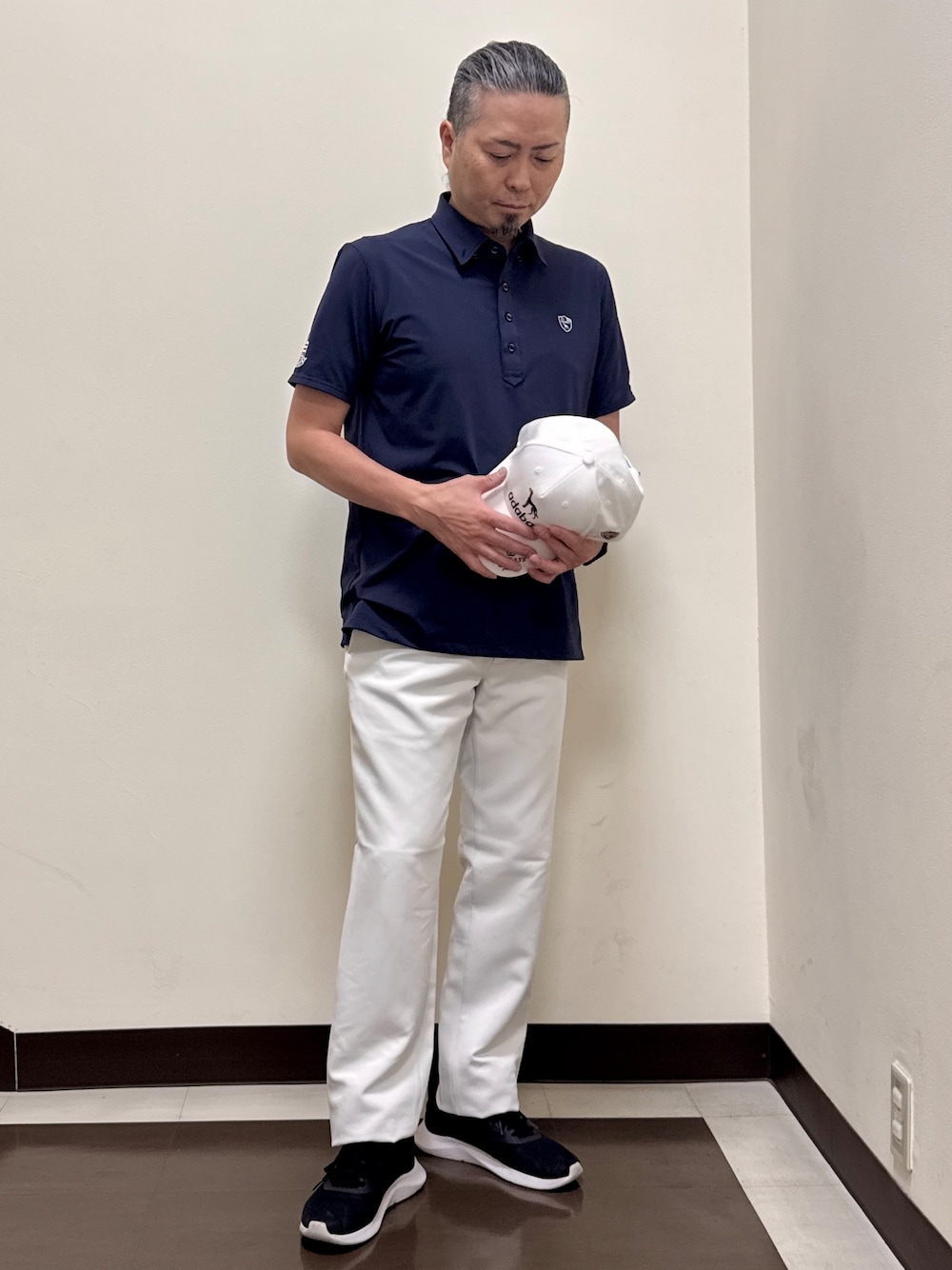 ブルー系のポロシャツ、グレー系のその他パンツ、ホワイト系のキャップを着用したメンズの夏コーディネートの3枚目の写真